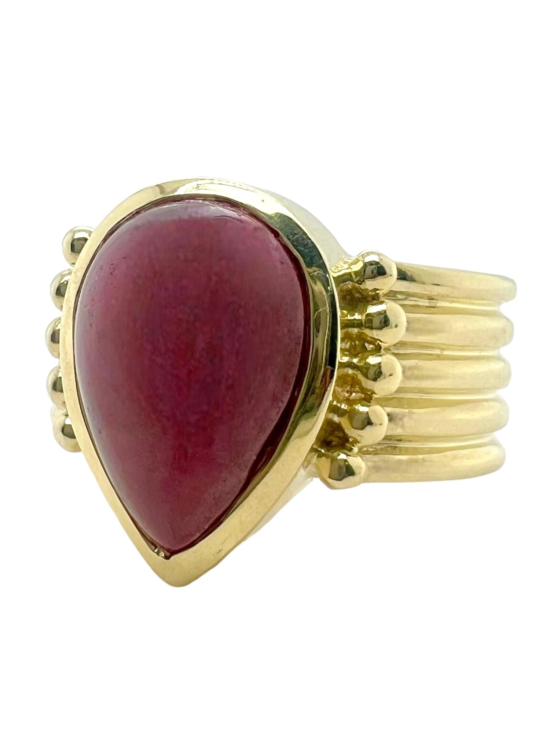 This stunning ring features a lustrous pear-shaped ruby cabochon, known for its deep, rich red color and smooth, rounded surface. Set in a striking 14K gold band with a ribbed texture, the ring combines classic elegance with modern flair. The ribbed