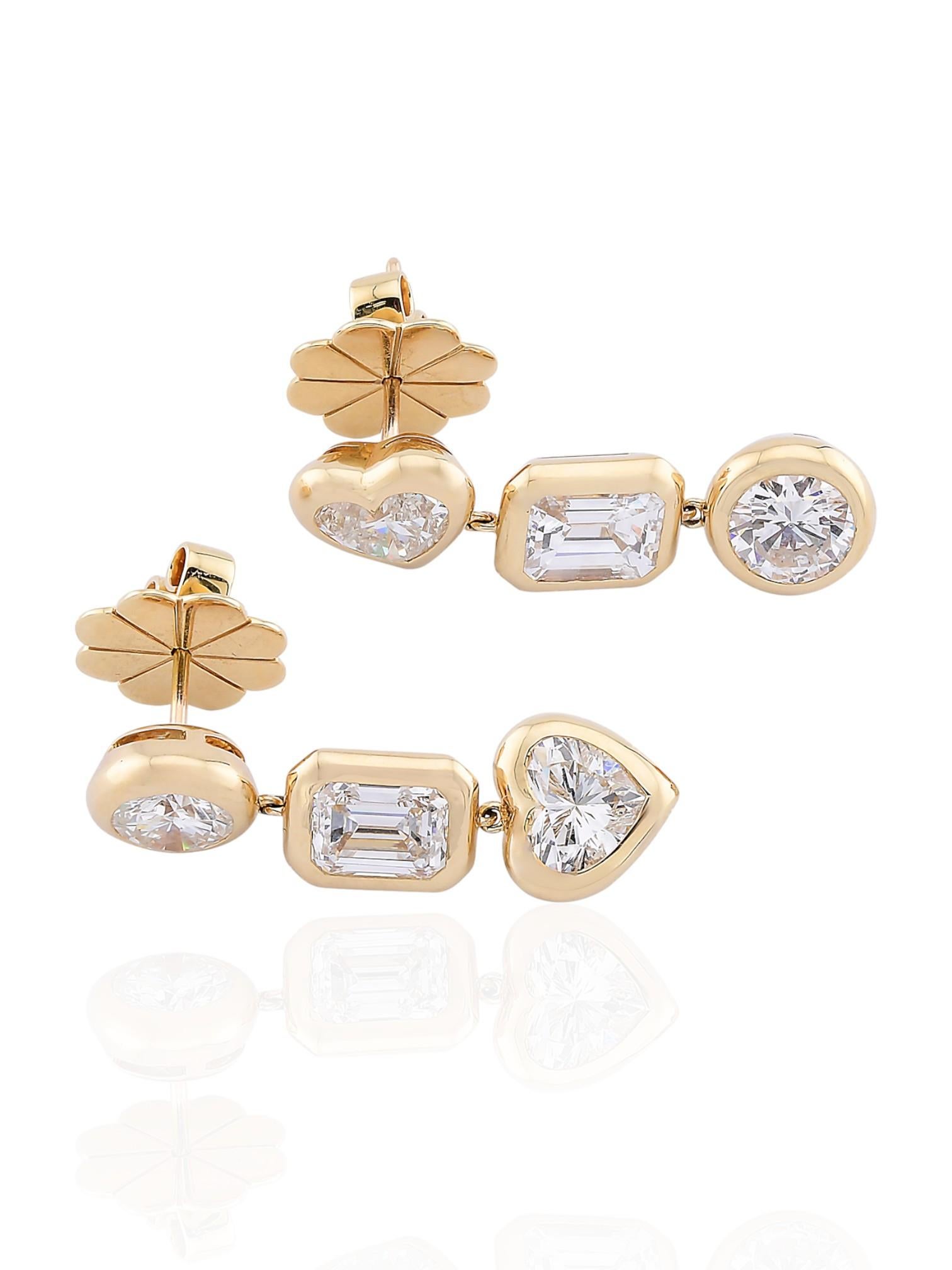 Ces boucles d'oreilles géométriques présentent un jeu de formes saisissant - cœur, émeraude et rond - chacune sertie de diamants naturels d'une valeur totale de 5,51 carats. Réalisé en or jaune 18 carats, ce modèle allie chaleur et brillance, chaque