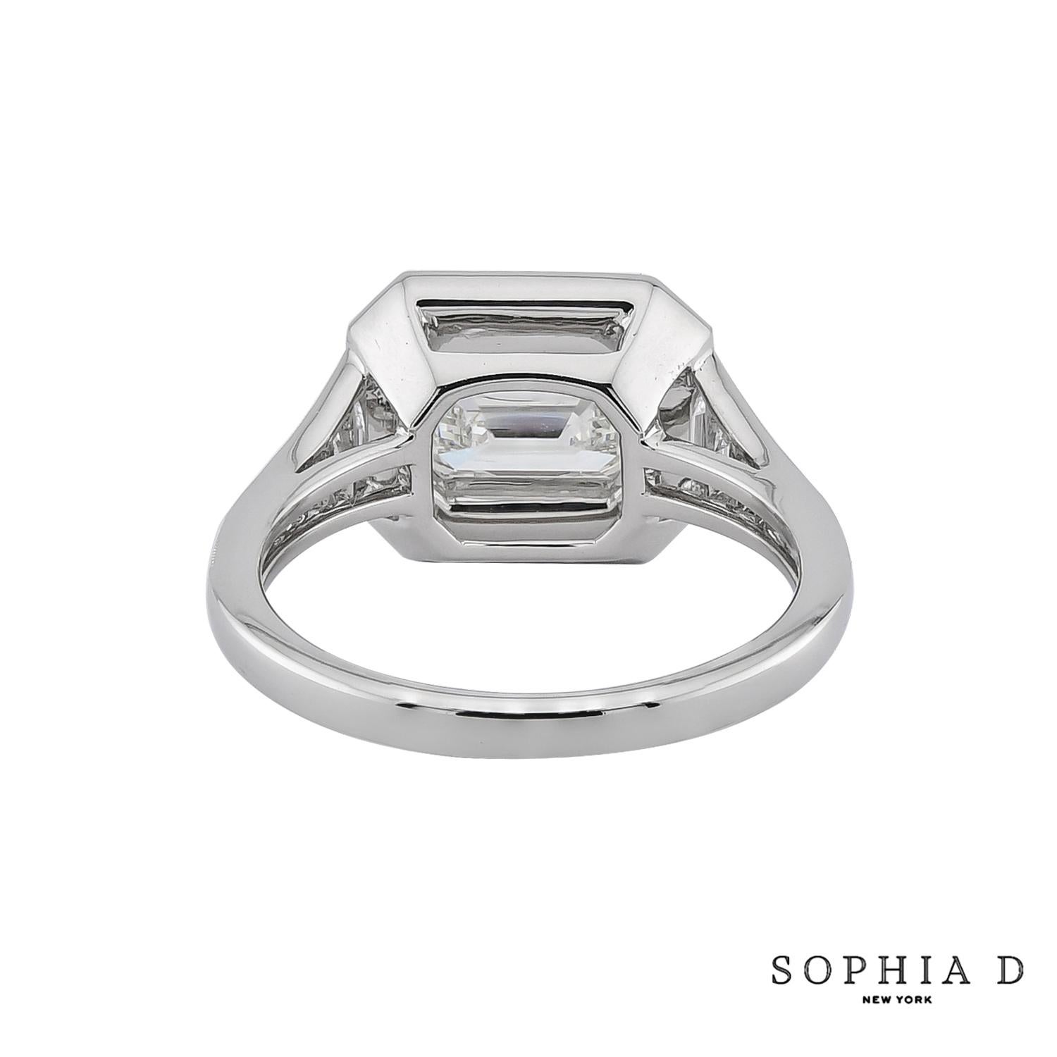 This Art Deco-inspired ring features a 1.30-carat east-west set emerald-cut diamond as its centerpiece, emphasizing sleek geometry and refined elegance. Accented with 0.60 carats of round diamonds and 0.55 carats of calibré-cut onyx, the design