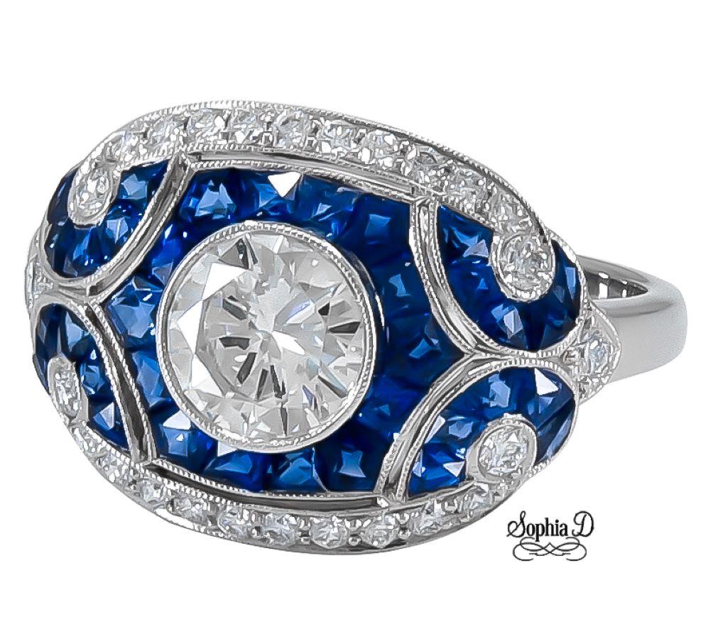Art deco inspired ring by Sophia D. that features a 1.08 carat round center diamond, 0.28 carat small round diamonds and 1.30 carat blue sapphires set in platinum.

Sophia D by Joseph Dardashti LTD has been known worldwide for 35 years and are