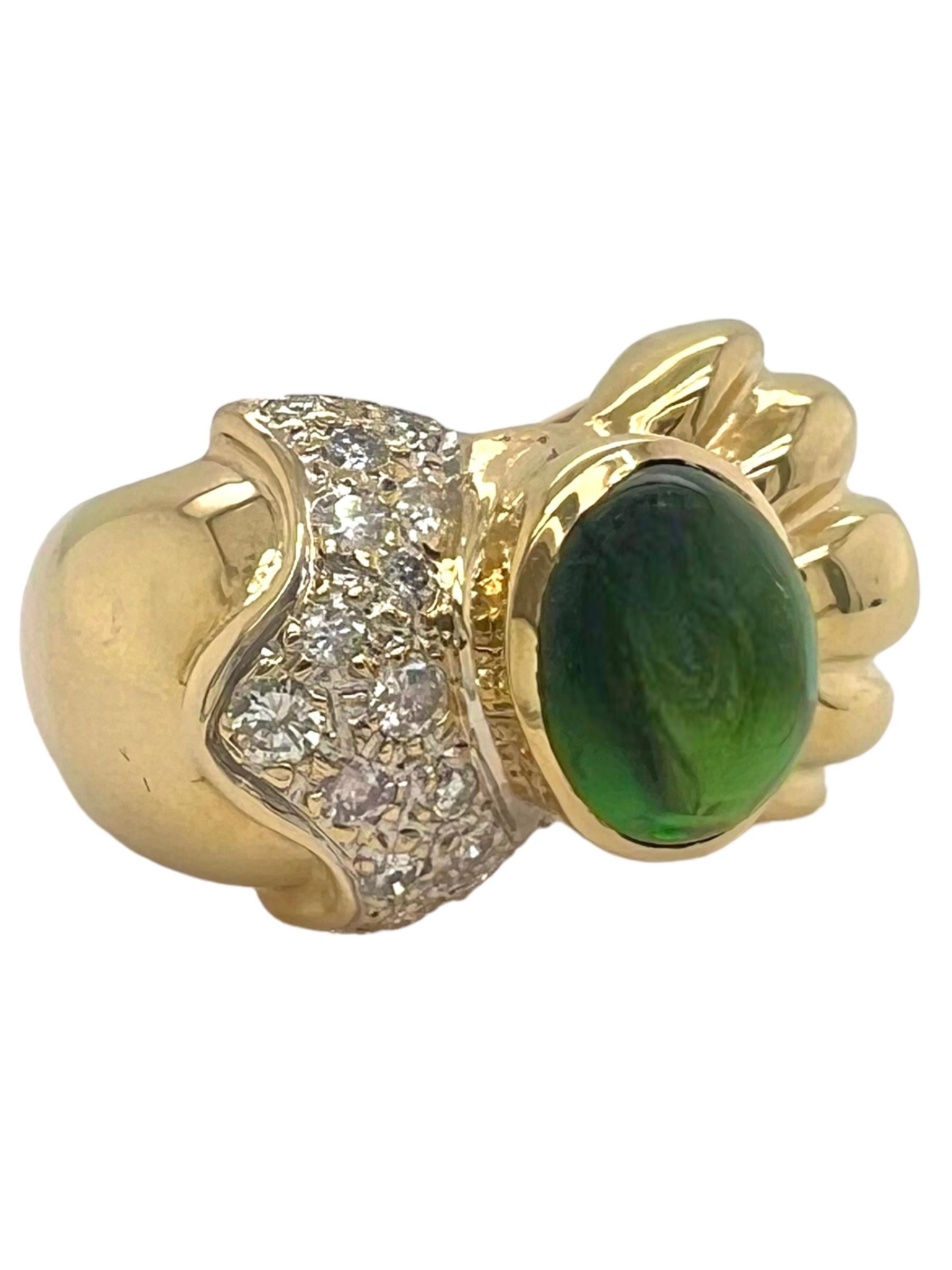 Dieser raffinierte Ring zeigt in der Mitte einen Smaragd-Cabochon, der für seine tiefe, sattgrüne Farbe und sein glattes, abgerundetes Profil bekannt ist. Der Smaragd wird auf einer Seite von eleganten Diamanten flankiert, die für einen Hauch von