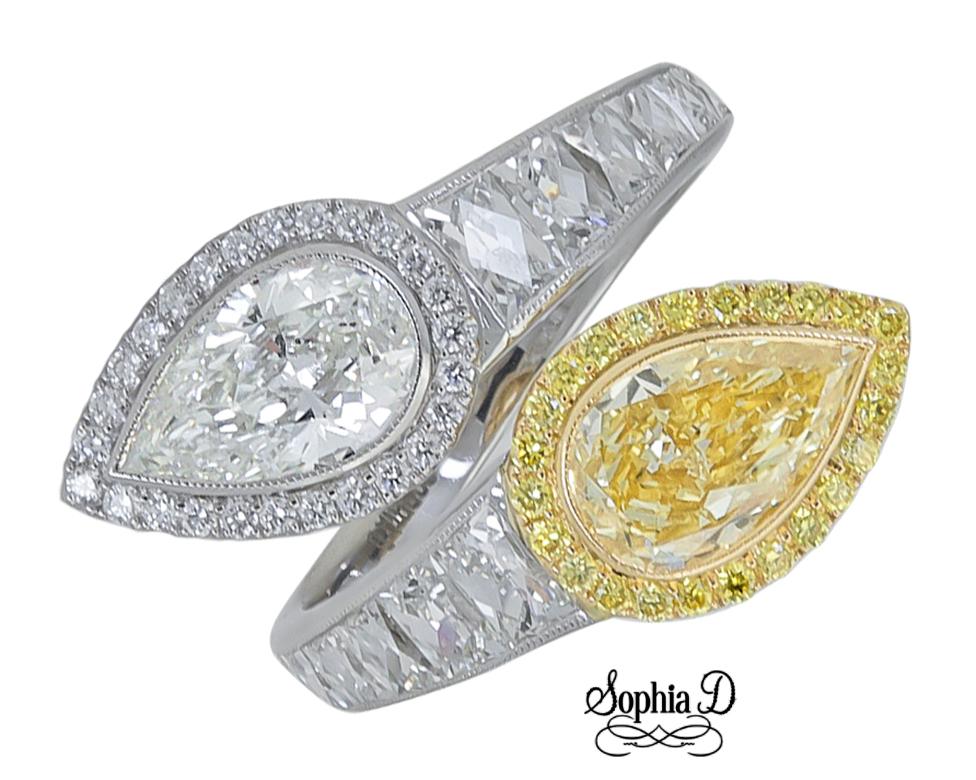 This GIA certified ring set in platinum features a 1.32 carat pear shaped yellow diamond, 1.06 carat pear shaped diamond,  1.24 carat square diamonds, 0.16 carat surrounding round yellow diamonds, 0.12 carat surrounding round diamond.

Sophia D by
