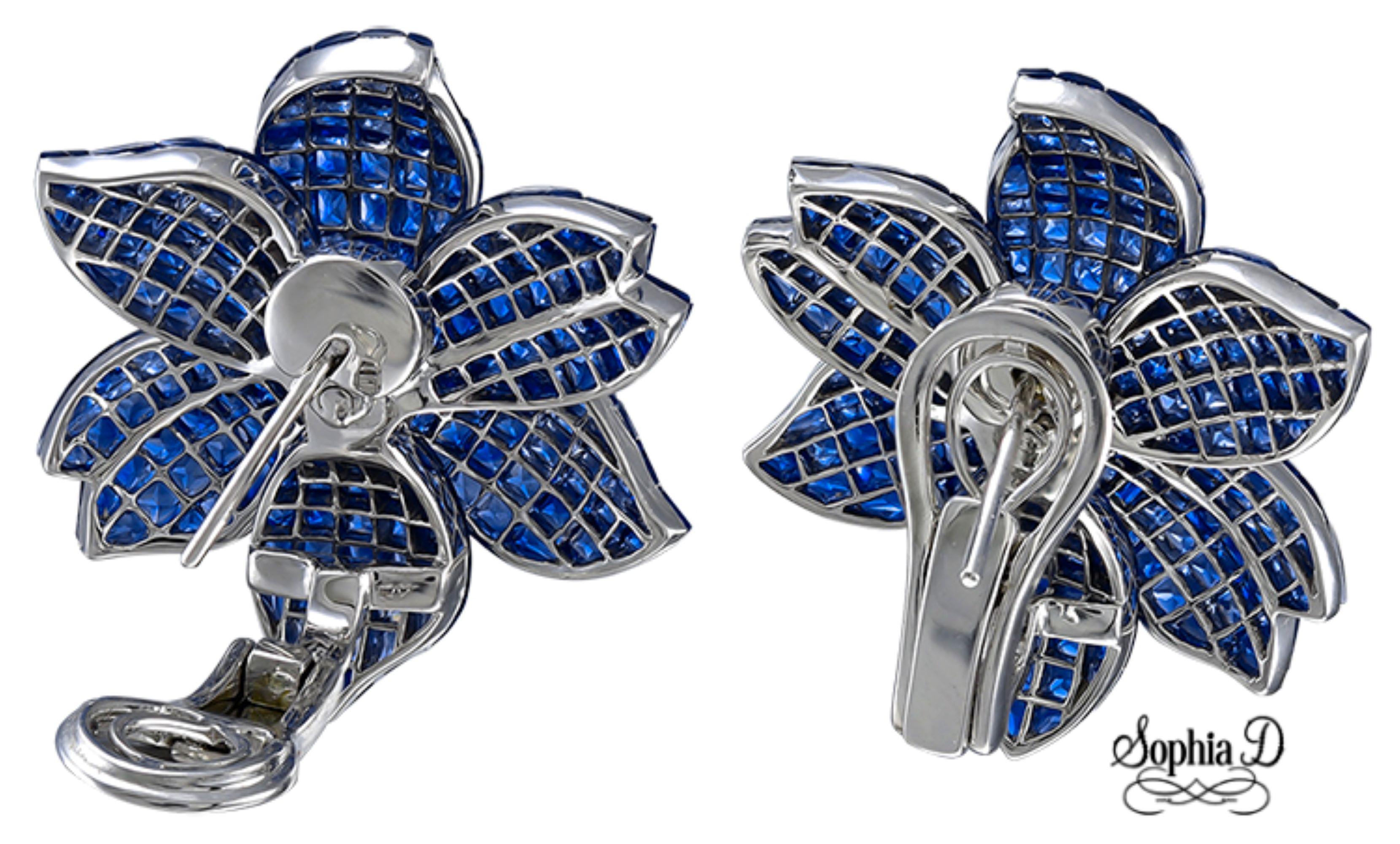 Réalisées en or blanc 18 carats, ces boucles d'oreilles Sophia D mettent en valeur 20,64 carats de saphirs bleus et 1,12 carat de diamants dans un motif floral raffiné. Le sertissage invisible permet de mettre en valeur les pierres vibrantes,