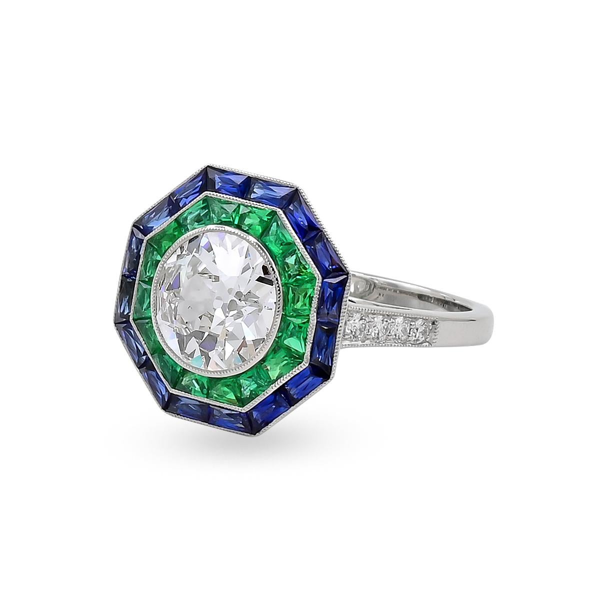 Ein einzigartiger Sophia D Ring im Art-Deco-Stil mit einem runden Diamanten in der Mitte, umgeben von Smaragden im französischen Schliff und blauen Saphiren und akzentuiert mit runden Diamanten, gefasst in Platin.

Gesamtgewicht des zentralen