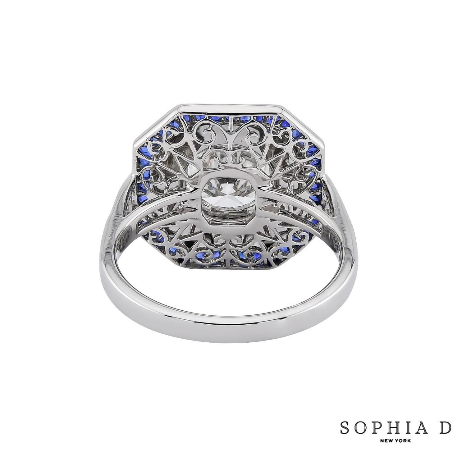 Cette bague d'inspiration Art déco présente un diamant rond de 1,65 carat taillé en brillant, serti dans un cadre de 0,30 carat de cristal de roche taillé, créant ainsi une profondeur visuelle saisissante. Un halo de saphirs de taille française de