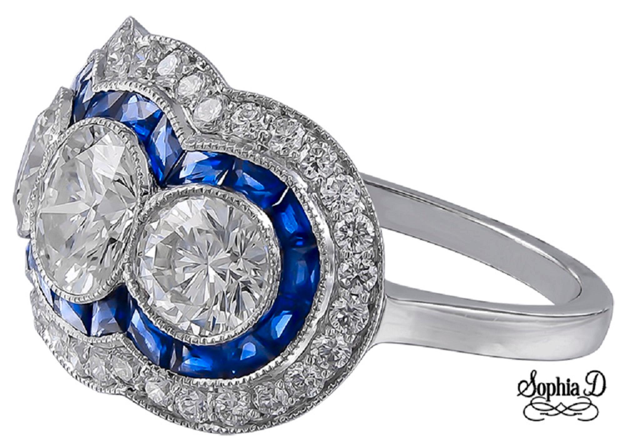 Questo anello in platino Sophia D. presenta uno splendido design con tre pietre e un peso totale di 1,12 carati. Intorno ai diamanti centrali ci sono zaffiri vibranti per un totale di 0,33 carati, completati da altri 0,65 carati di diamanti che