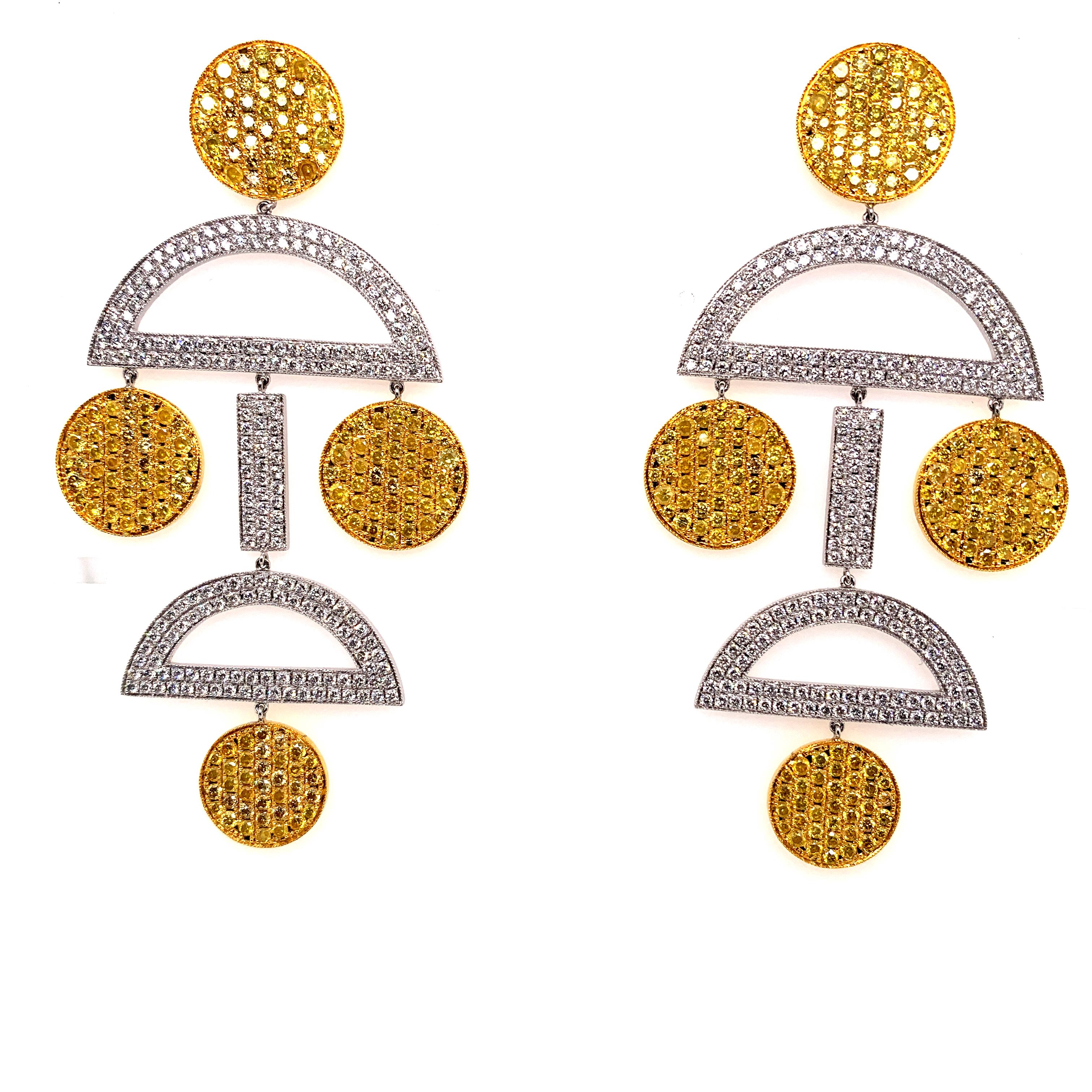 These elegant drop earrings feature 6.44 carats of vivid yellow diamonds, set in 18K yellow gold. The yellow diamonds are complemented by 3.86 carats of white diamonds, set in platinum, which add a contrasting brilliance. The combination of metals