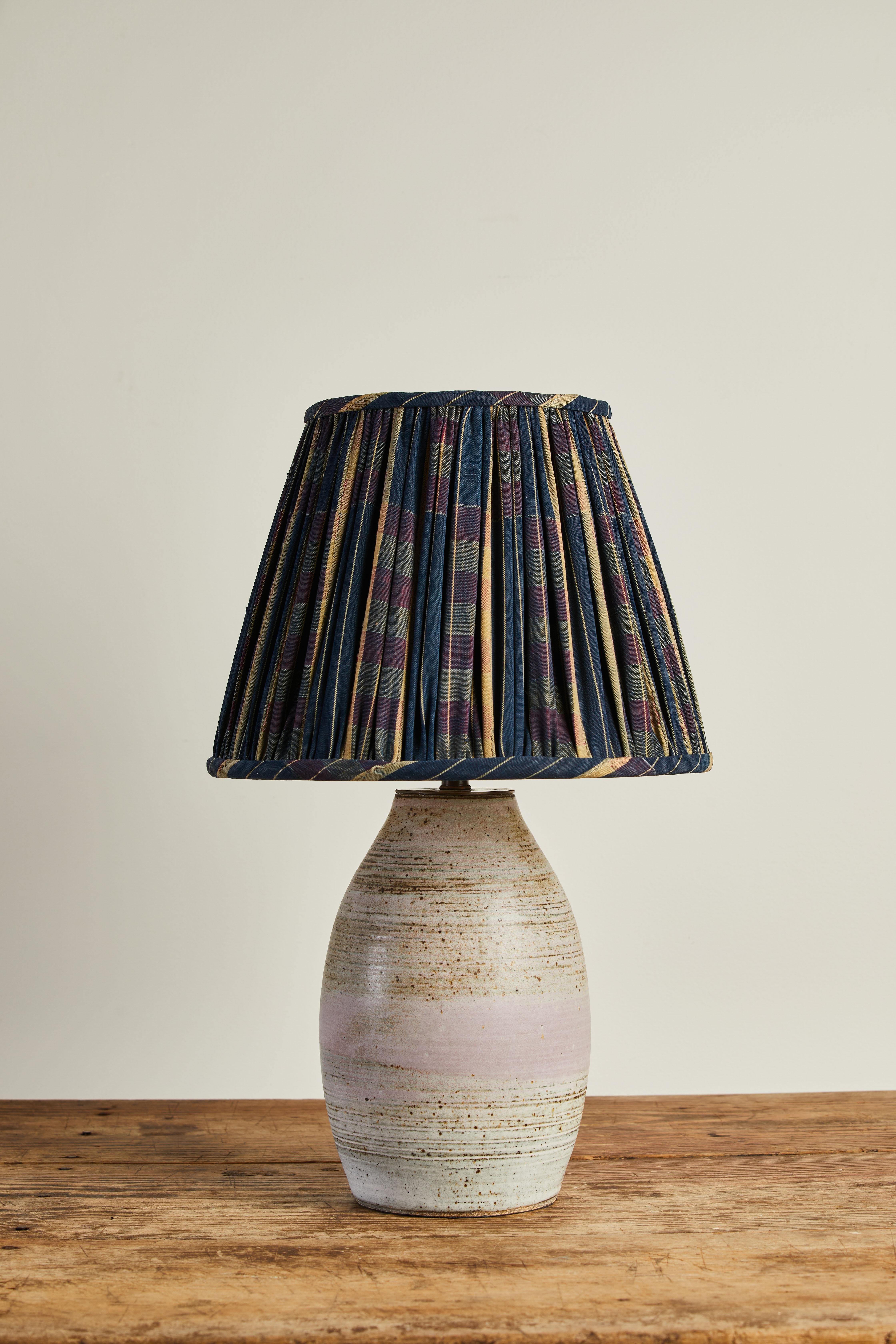 Sophia Studio white glazed ceramic table lamp with custom shirred blue and white lampshade made from vintage African fabric.