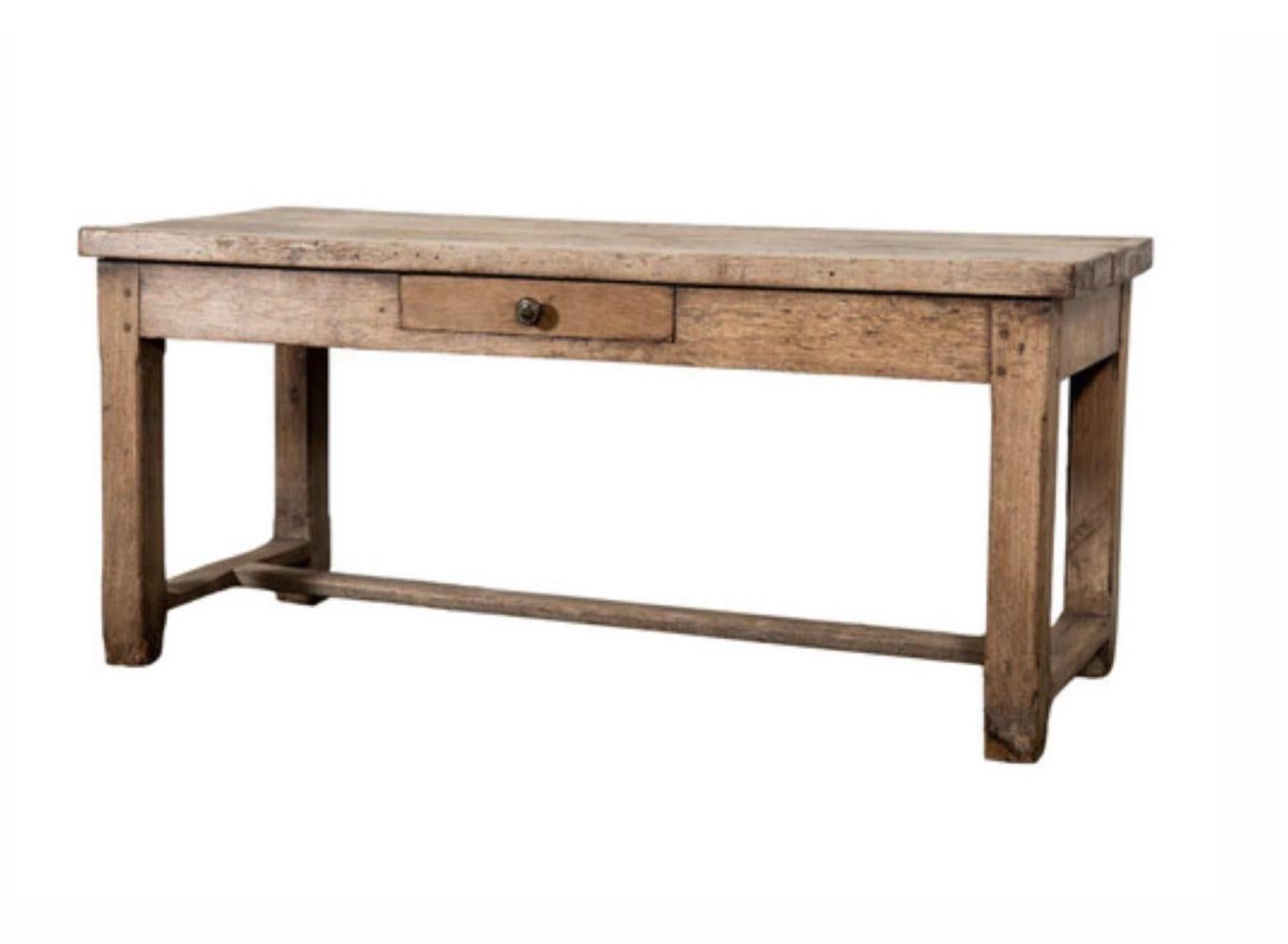 Charming early 1900s French Provincial oak farm table, aged and weathered to perfection. Supported by an H-shaped base, this versatile piece features a convenient single drawer on the front. With its multifunctional design, it can effortlessly serve