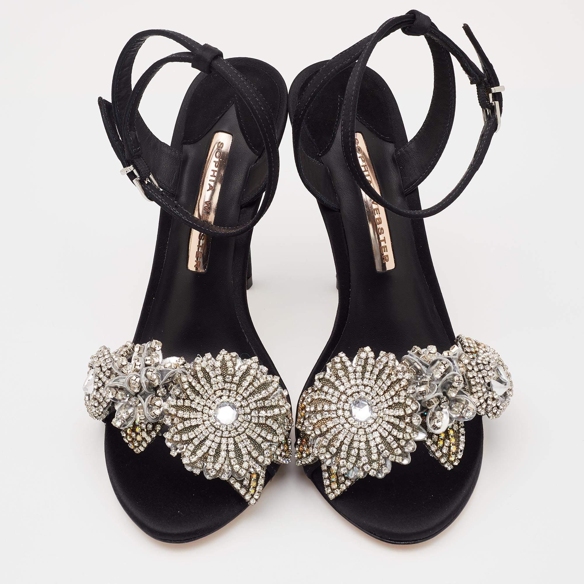 Create your own style statement with these fashionable sandals from Sophia Webster. These black sandals are crafted from satin and feature an open toe silhouette. They flaunt lovely flowers embellished on the vamp straps and come equipped with