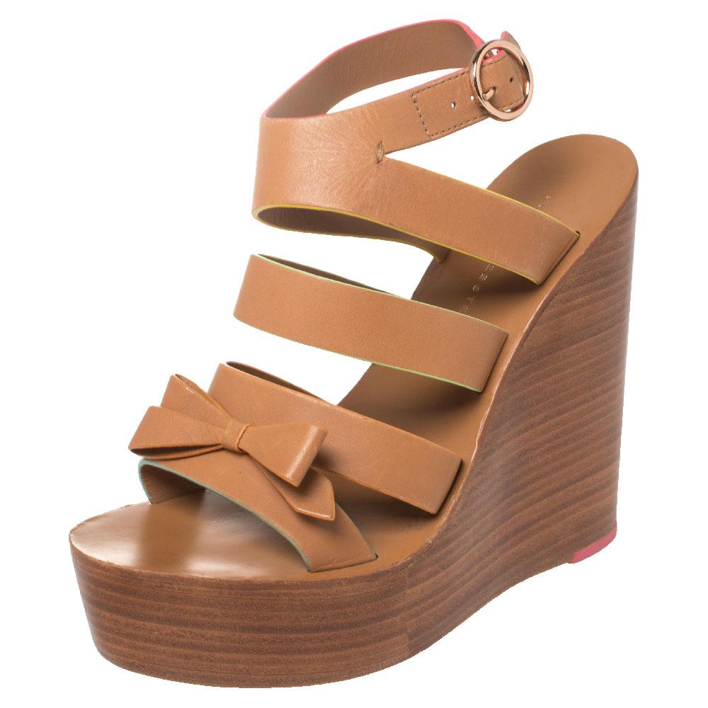 These lovely Sophia Webster wedge sandals will bring you the right amount of style and comfort. They feature brown leather straps with colorful finishing, little bow details, buckle fastenings, and 14 cm wedge heels for the right lift. They are