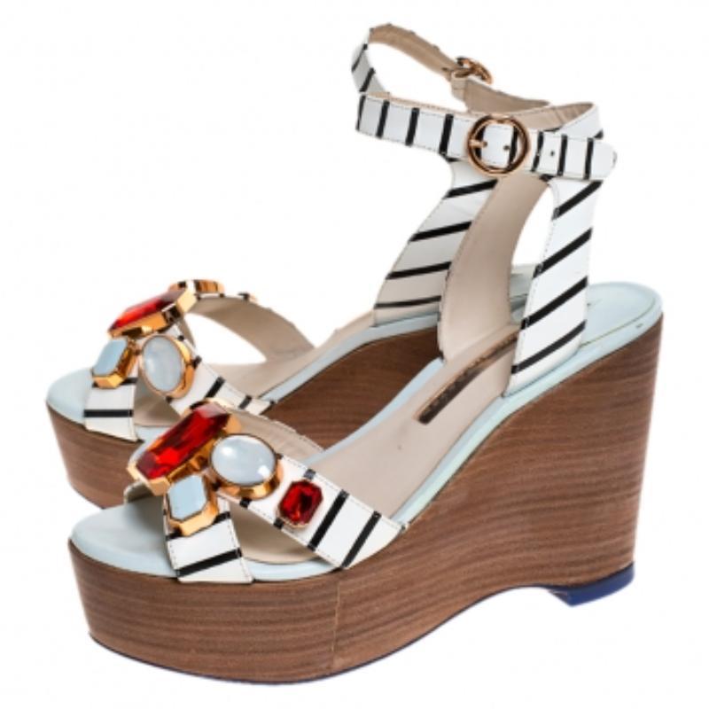 Estas impresionantes sandalias de cuña de Sophia Webster están diseñadas para elevar tu look al instante. Llevan tiras de piel adornadas para asegurar la parte delantera y finas tiras en los tobillos para sujetar bien los pies. Las sandalias se
