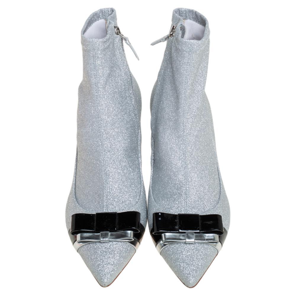 Diese knöchelhohen Stiefel von Sophia Webster wurden entworfen, um einen modischen Reiz zu präsentieren. Die Booties sind mit Glitzerstoff überzogen und mit Lederbesätzen, spitzen Zehen, seitlichen Reißverschlüssen und 7,5 cm hohen Absätzen