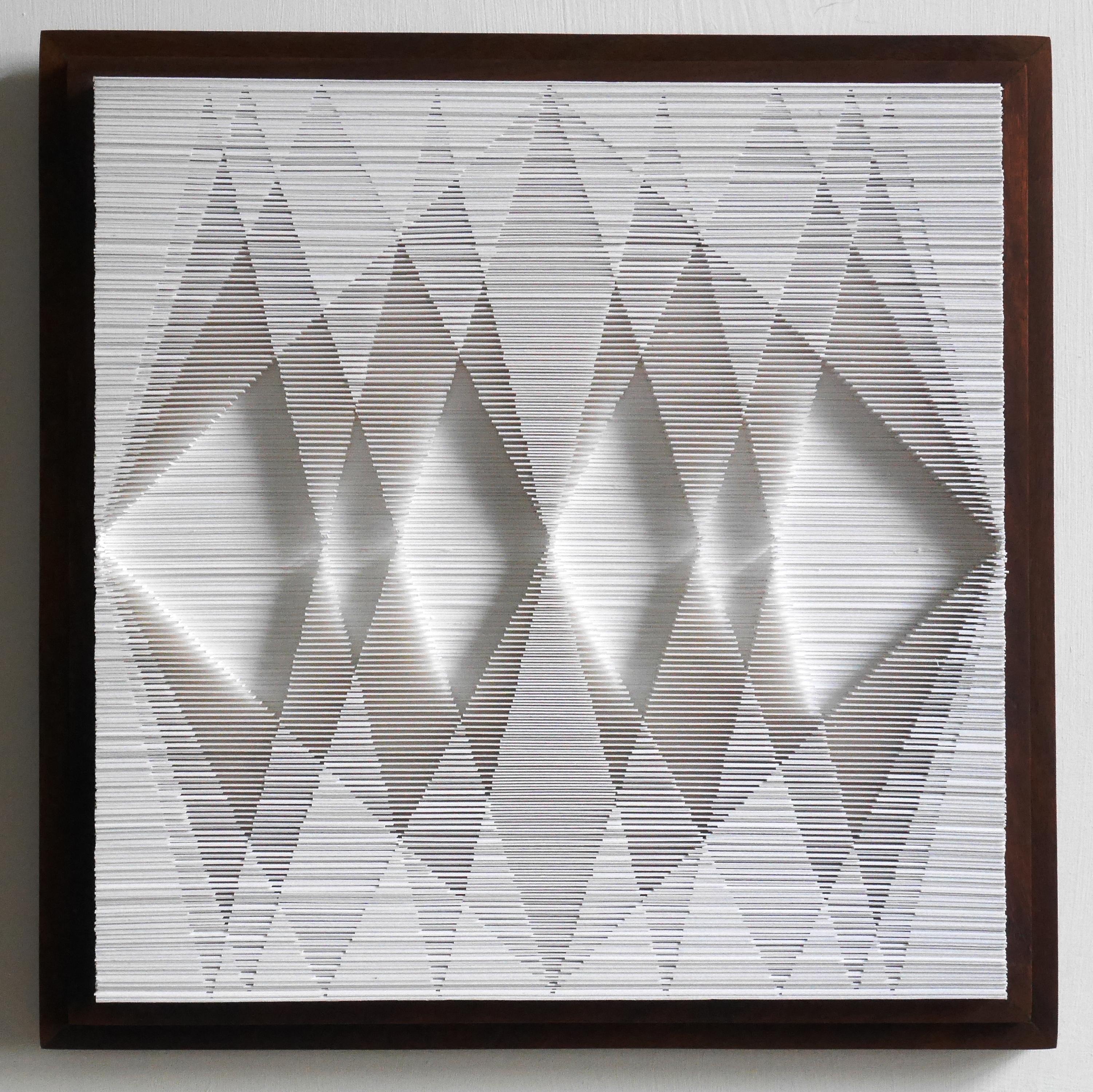 In this work, Sophie has taken the idea of stacked paper and turned it into a visual and contemplative experience.  Mounted in a wooden box frame, the cut edge of the paper forms a series of triangles that change shape as you move.  This piece is
