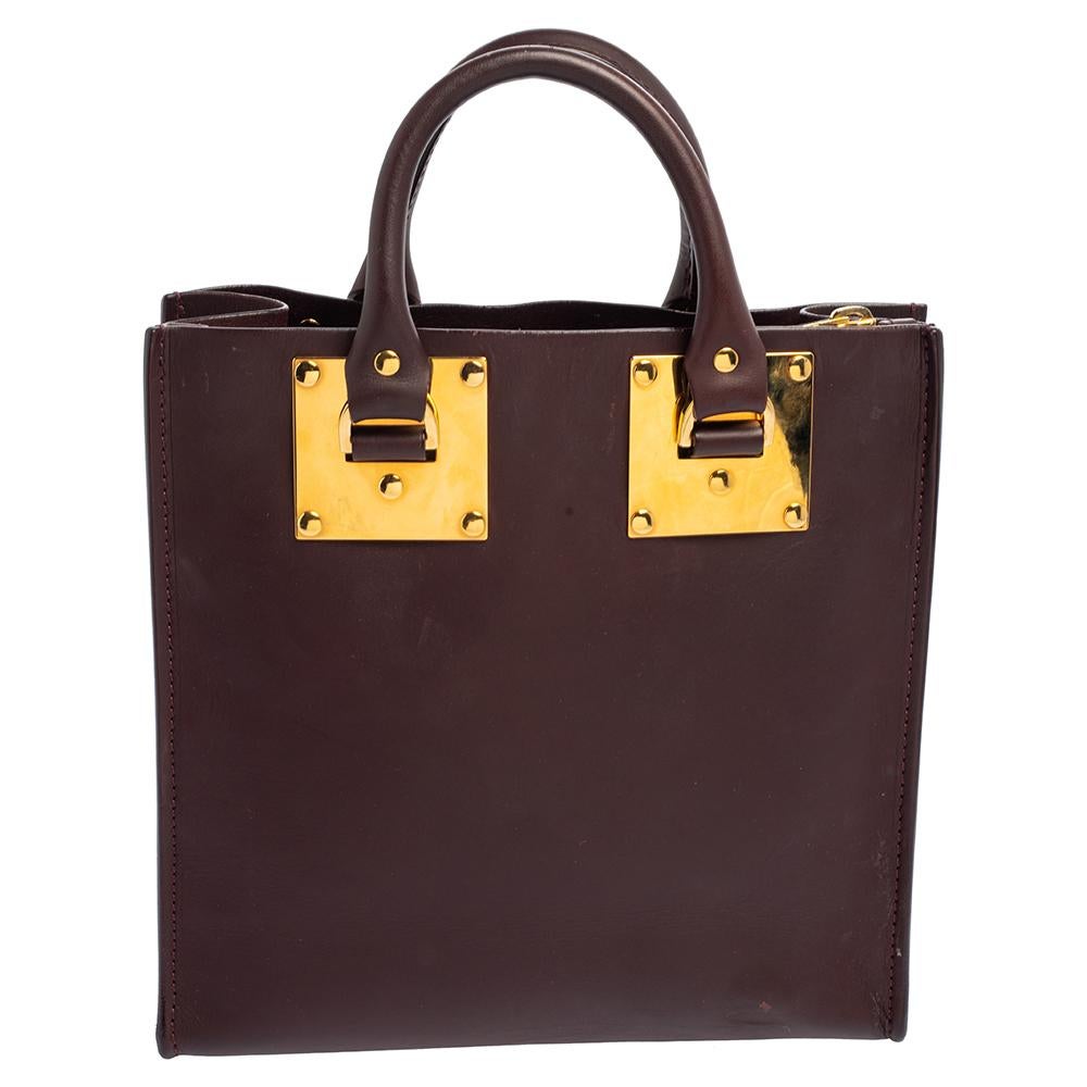 This burgundy Albion Square Tote, crafted in smooth leather has the iconic box silhouette that will carry all of your daily necessities season after season. Lined with suede on the inside, this tote handbag by Sophie Hulme is the finest companion