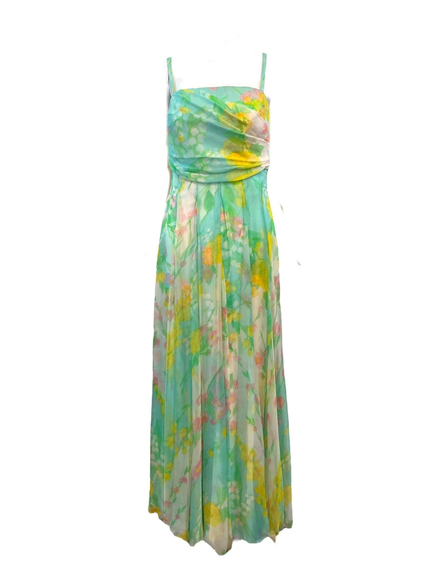 Simple and elegant - both signatures of designer Sophie Gimbel who went by the name Sophie of Saks. White silk chiffon with pastel watercolor floral print circa 1970s. Spaghetti straps, empire waist accompanied by a matching jacket. Fully lined with
