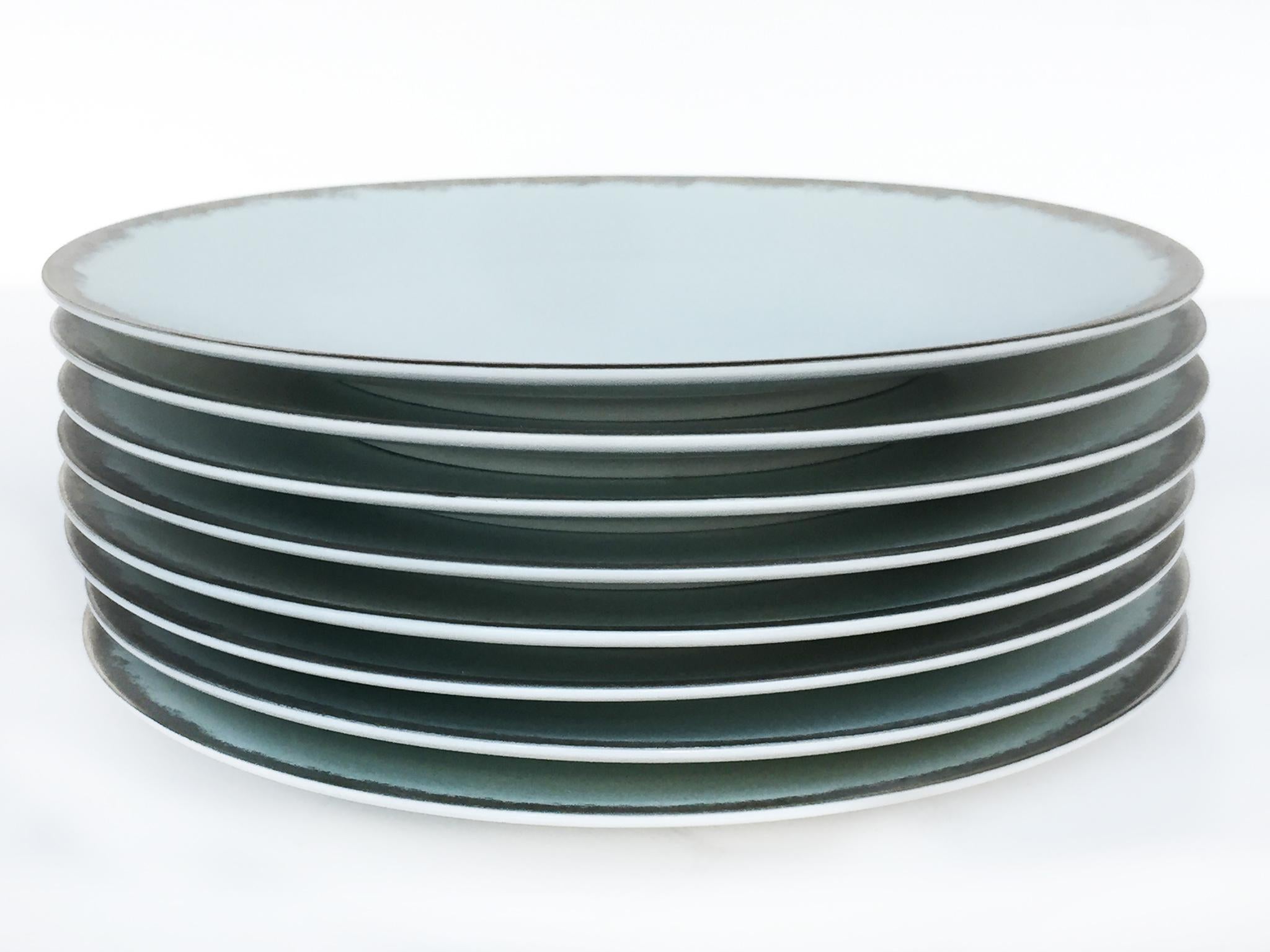 These 8 porcelain bread-&-butter plates were designed by Sophie Villepigue for Barneys New York. They were made in Limoges, France and delicately hand painted in Paris: a bronzed rim and gray matte finish with the subtlest hint of blue. There's an