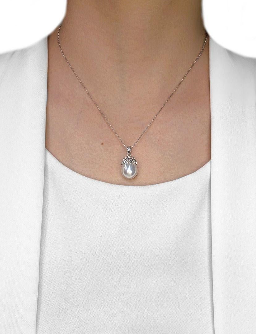 A stunning fusion of elegance and luminous beauty, this 18K white gold pendant showcases a magnificent 12.1mm oval South Sea pearl, exuding a soft, radiant glow that embodies luxury and refinement. Surrounding this exquisite centerpiece, 21 round