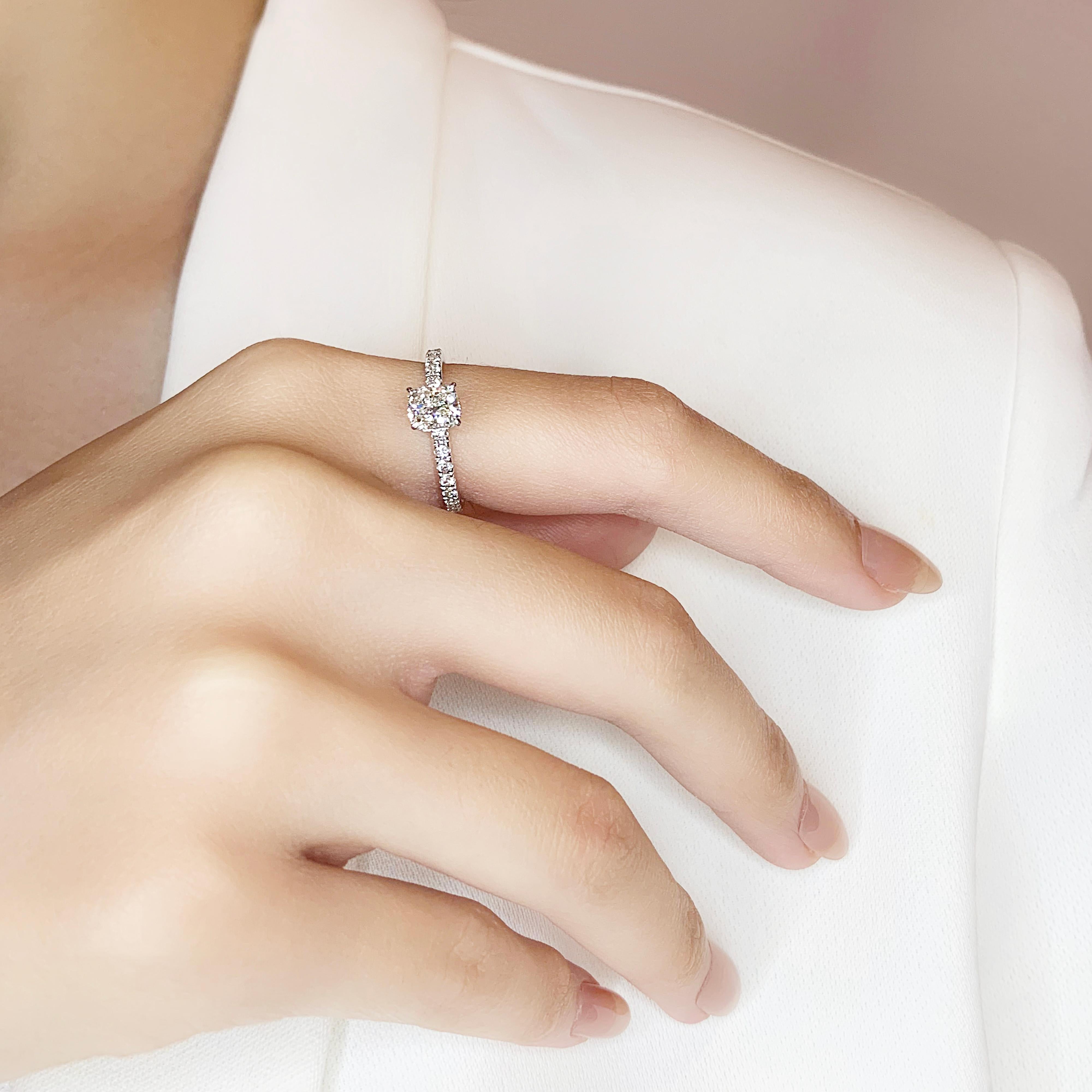 This splendid pave ring features a modified cushion-cut diamond as the centerpiece, weighing 0.81ct, and set in 18K white gold. The main stone boasts a K color grade and VVS2 clarity grade, ensuring exceptional brilliance and clarity. Adding to its