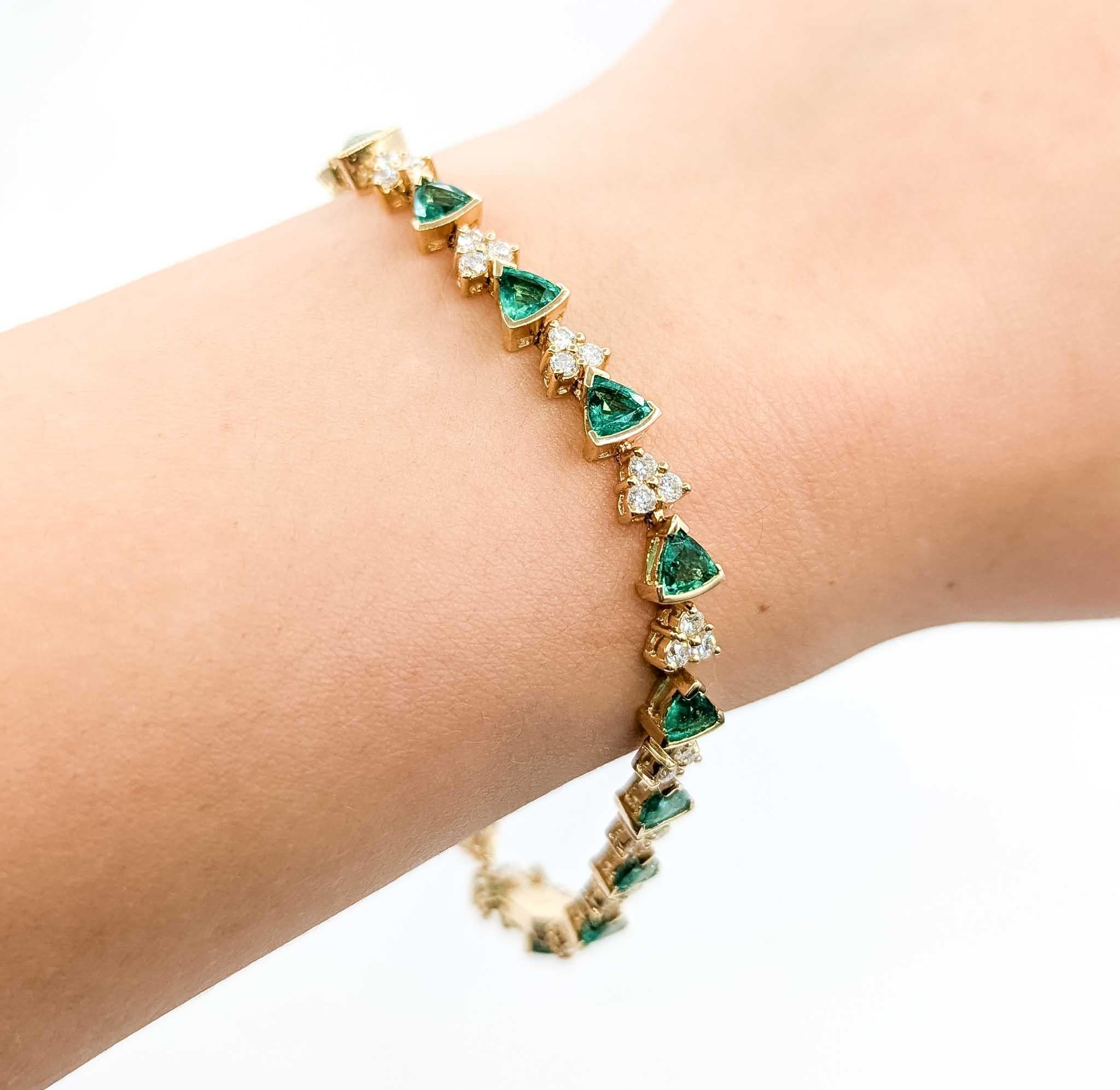Esta llamativa pulsera está elaborada en oro amarillo de 14 quilates y diseñada con eslabones alternados de esmeraldas verdes intensas y diamantes brillantes. La pulsera exhibe aproximadamente 3,60 quilates de esmeraldas de talla triangular