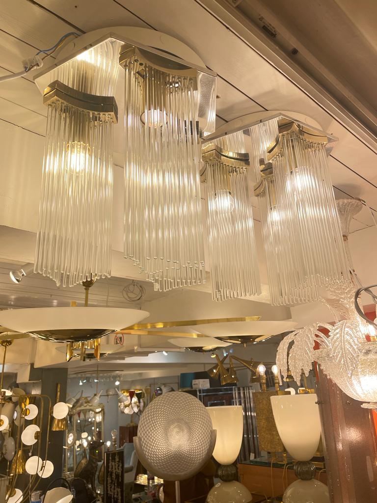 This glamorous pair of 1960 flush mount chandeliers feature one tier of Murano glass around three brass frames which support one chandelier bulb each suspended from a hexagonal stainless steel frame.