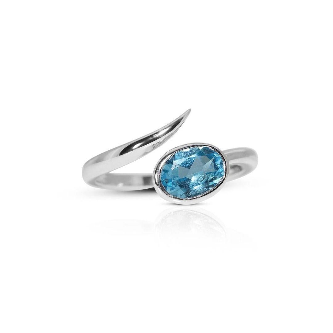 The 18K white gold band is sleek and sophisticated, ensuring the focus remains on the stunning blue stone. The combination of a luxurious precious metal and the bold, deep blue hue of the stone creates a timeless, upscale aesthetic, suitable for