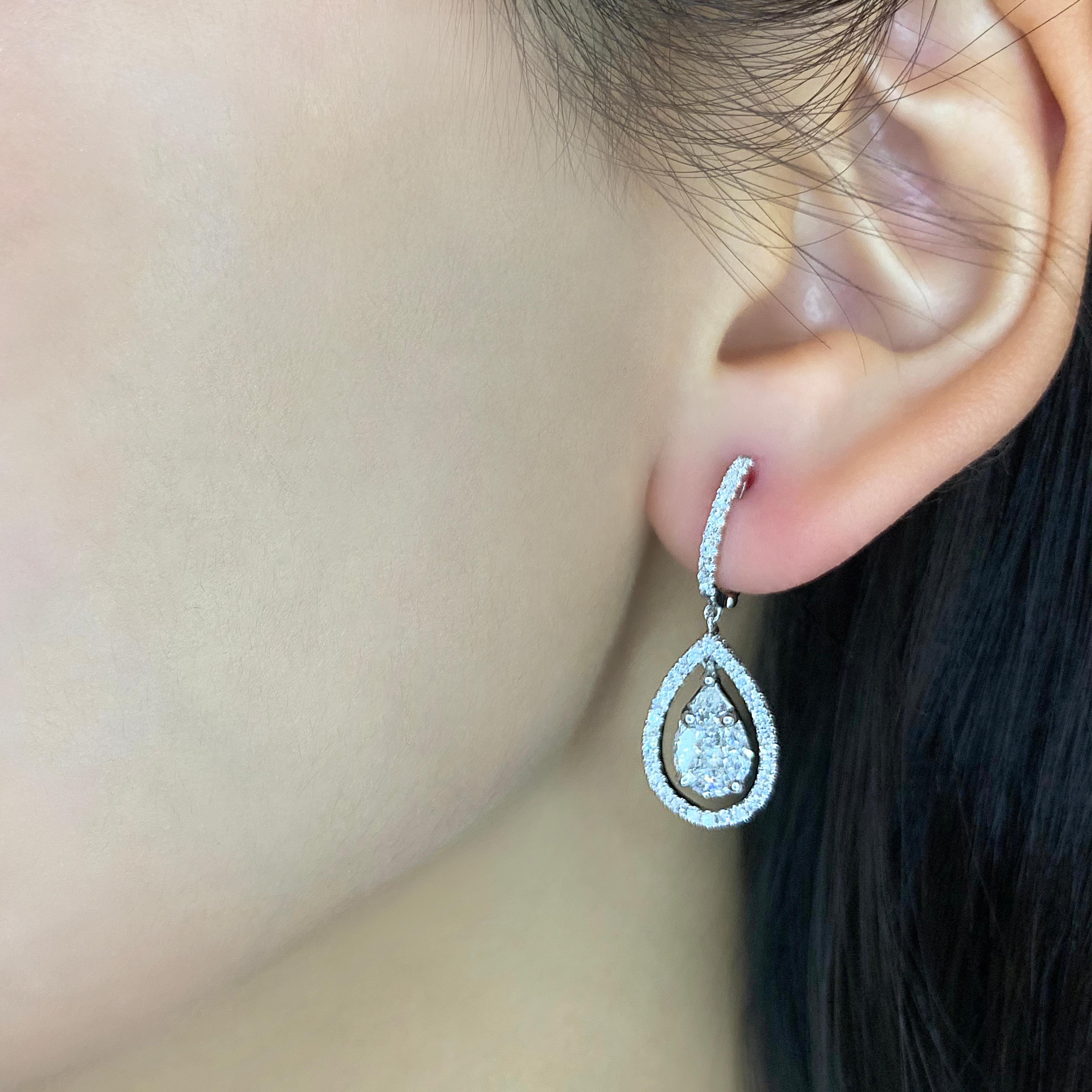 Indulge in the elegance of these sparkling earrings, featuring a stunning combination of natural diamonds set in 18K white gold. The earrings boast a total carat weight of 2.64ct, with pear-shaped, marquise, and princess-cut diamonds as the main