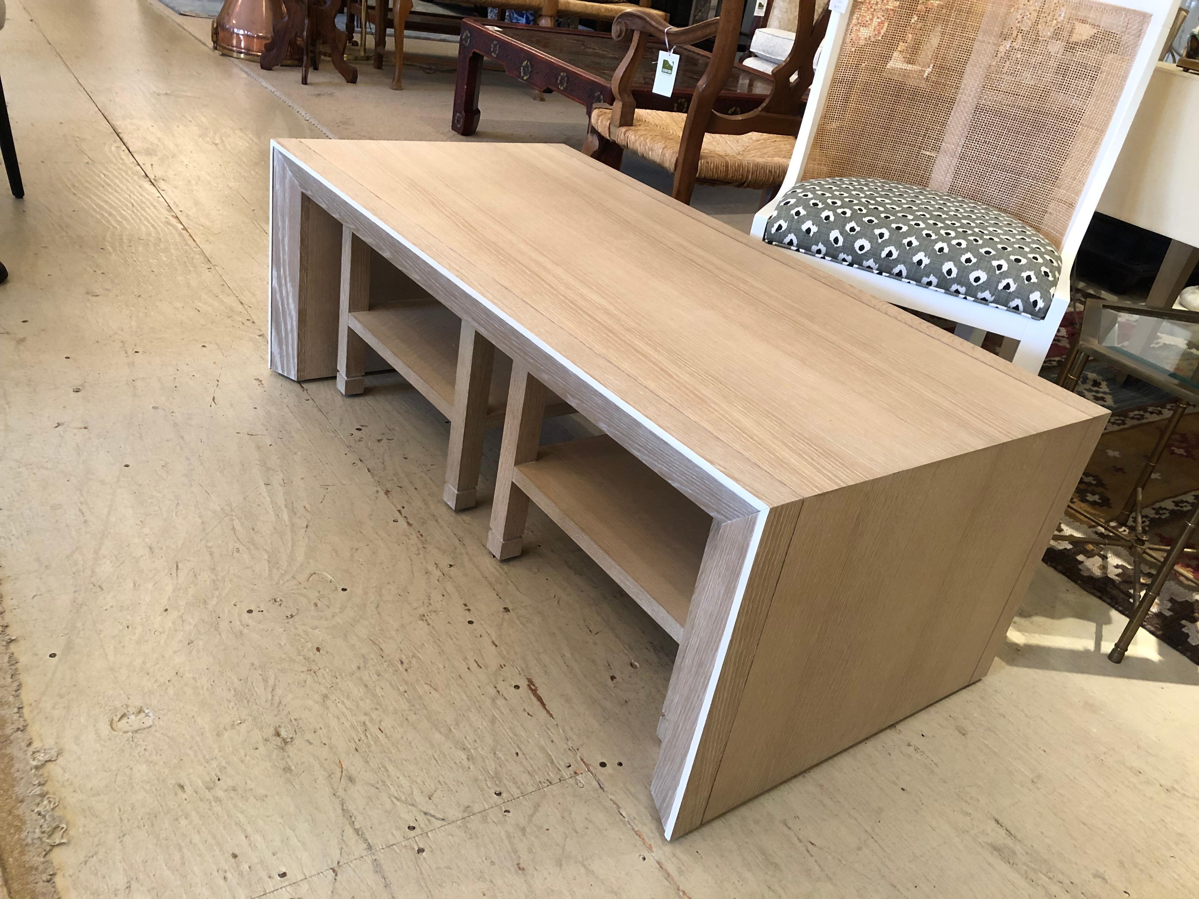 Sleek sophisticated coffee table and two matching end tables in a contemporary cerused wood. Legs are beautifully angularly shaped on the coffee table. End tables tuck under the cocktail table for storage and each measures 18