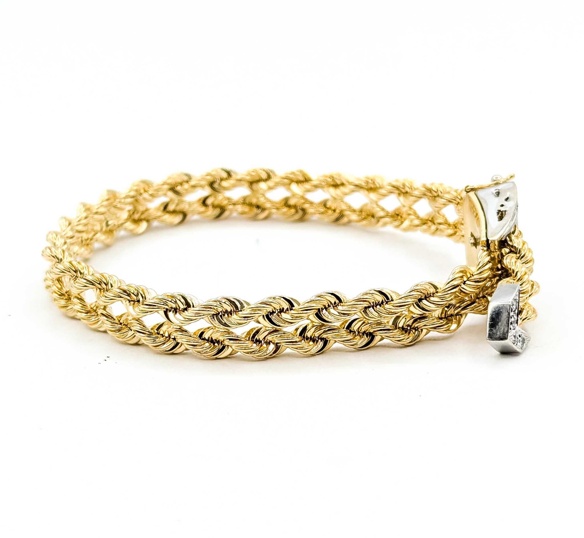 This striking double-strand rope bracelet is crafted in rich 14k yellow gold, offering both strength and timeless style. The intricate rope design is accented by a diamond-studded buckle clasp, set with approximately 0.35 carats total weight of