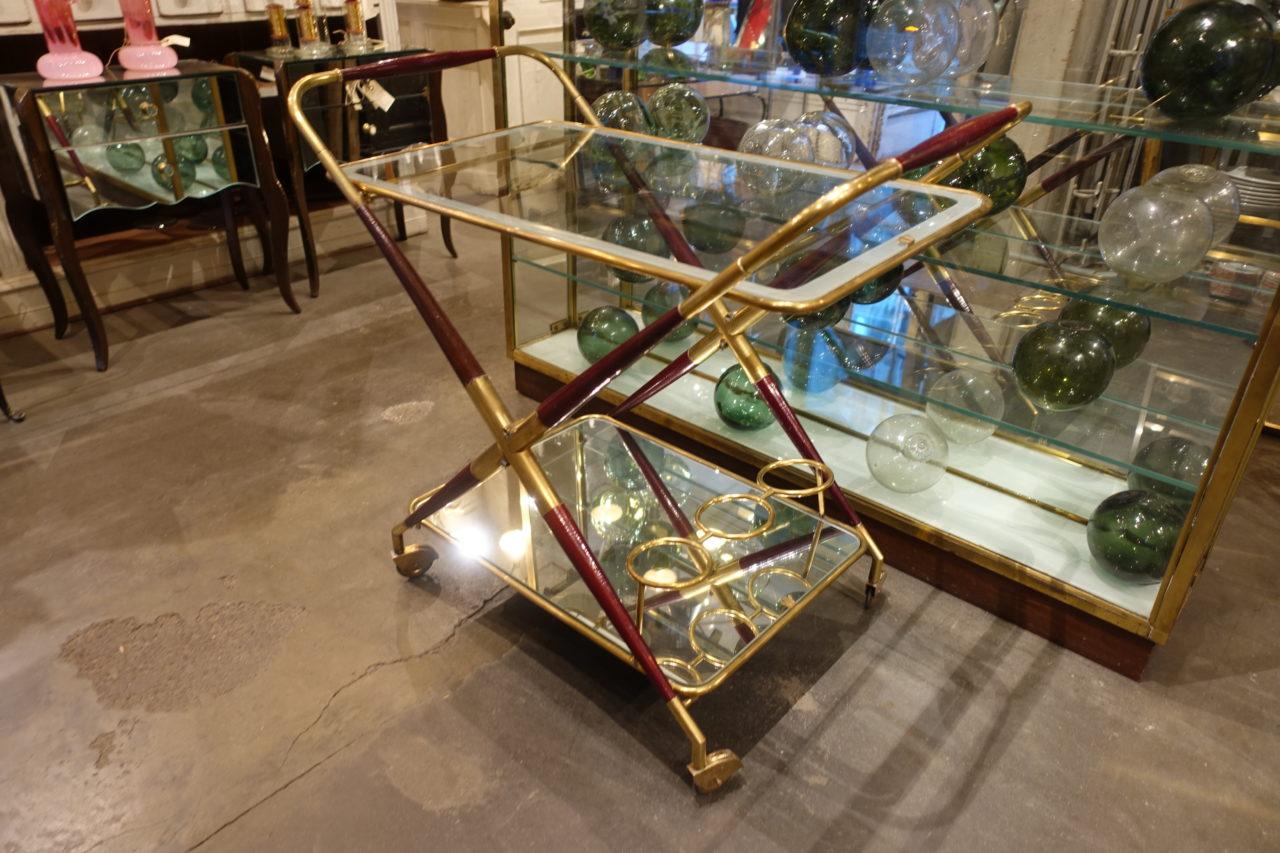 Elegant vintage serving trolley or bar cart, with a brass and wooden collapsible frame (great for storage). Beautifully made. The top shelf has its original glass, and the lower one is a mirror, for a wonderful effect. Inbuilt bottle holders. Lovely