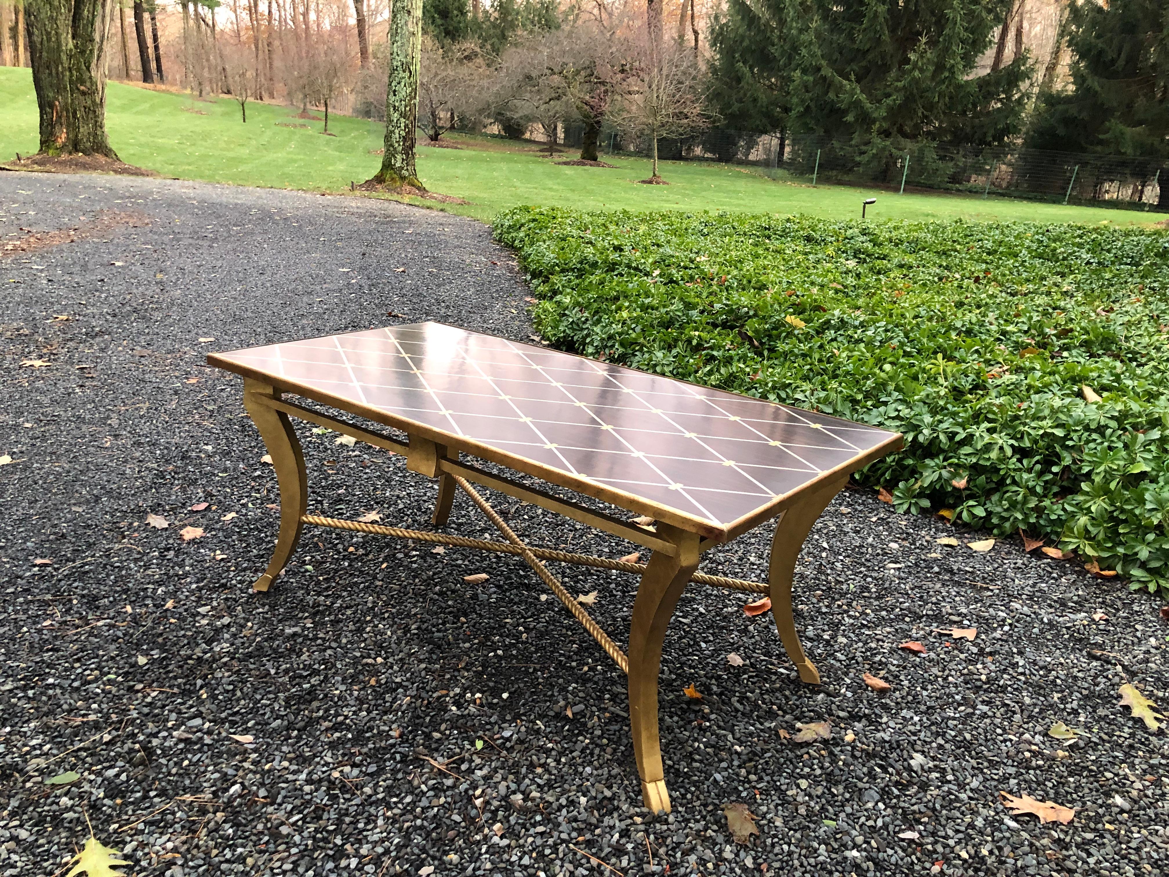 Transitional inlaid wood coffee table by Amy Howard. The table has a banded diamond design with an exotic wood background. Giltwood base has an X-form rope stretcher.