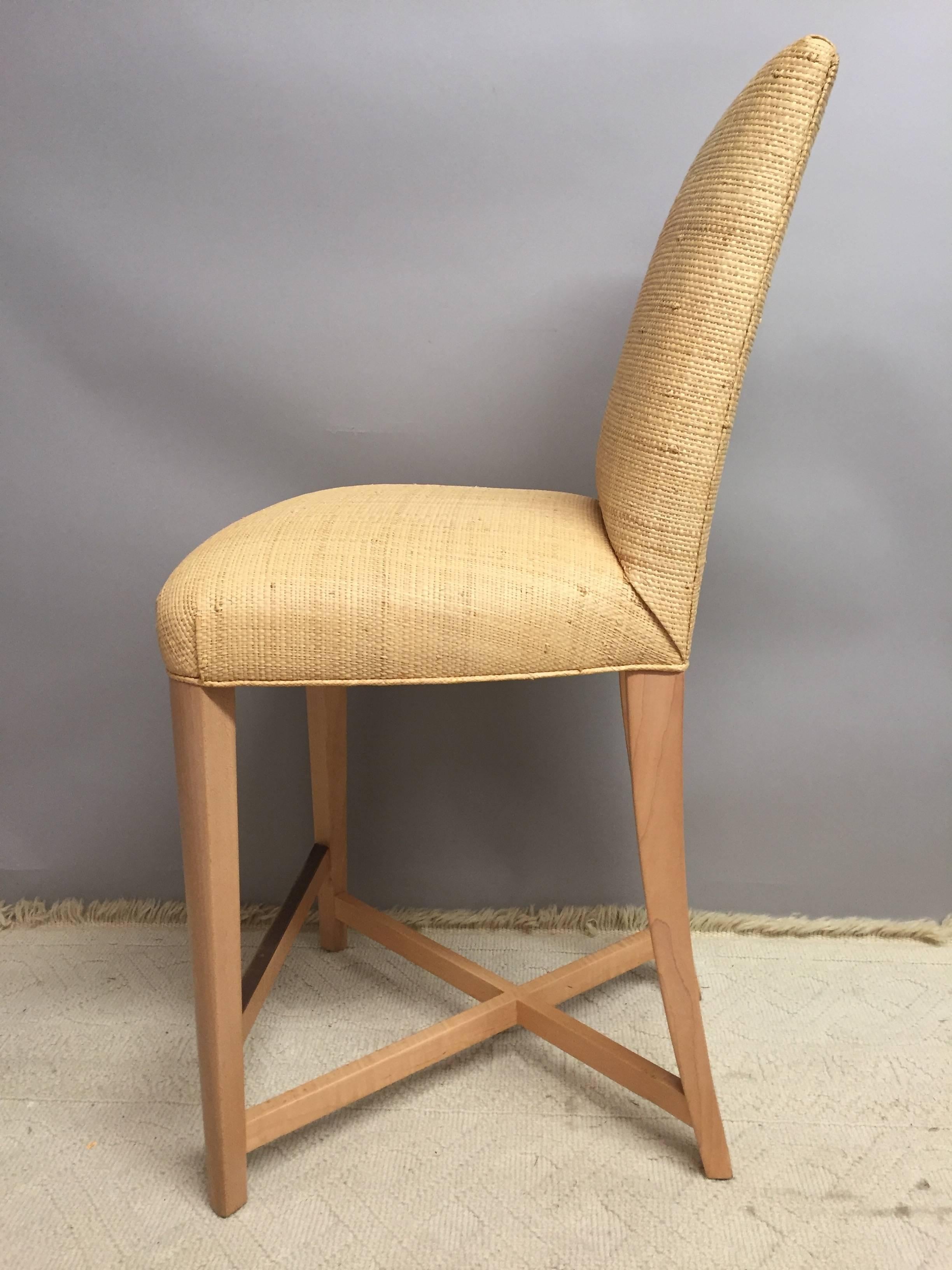 Pair of stunning bar stools having bleached wood legs with brass accents and natural colored raffia upholstery. Donghia label underneath.
Back width 13 inches.