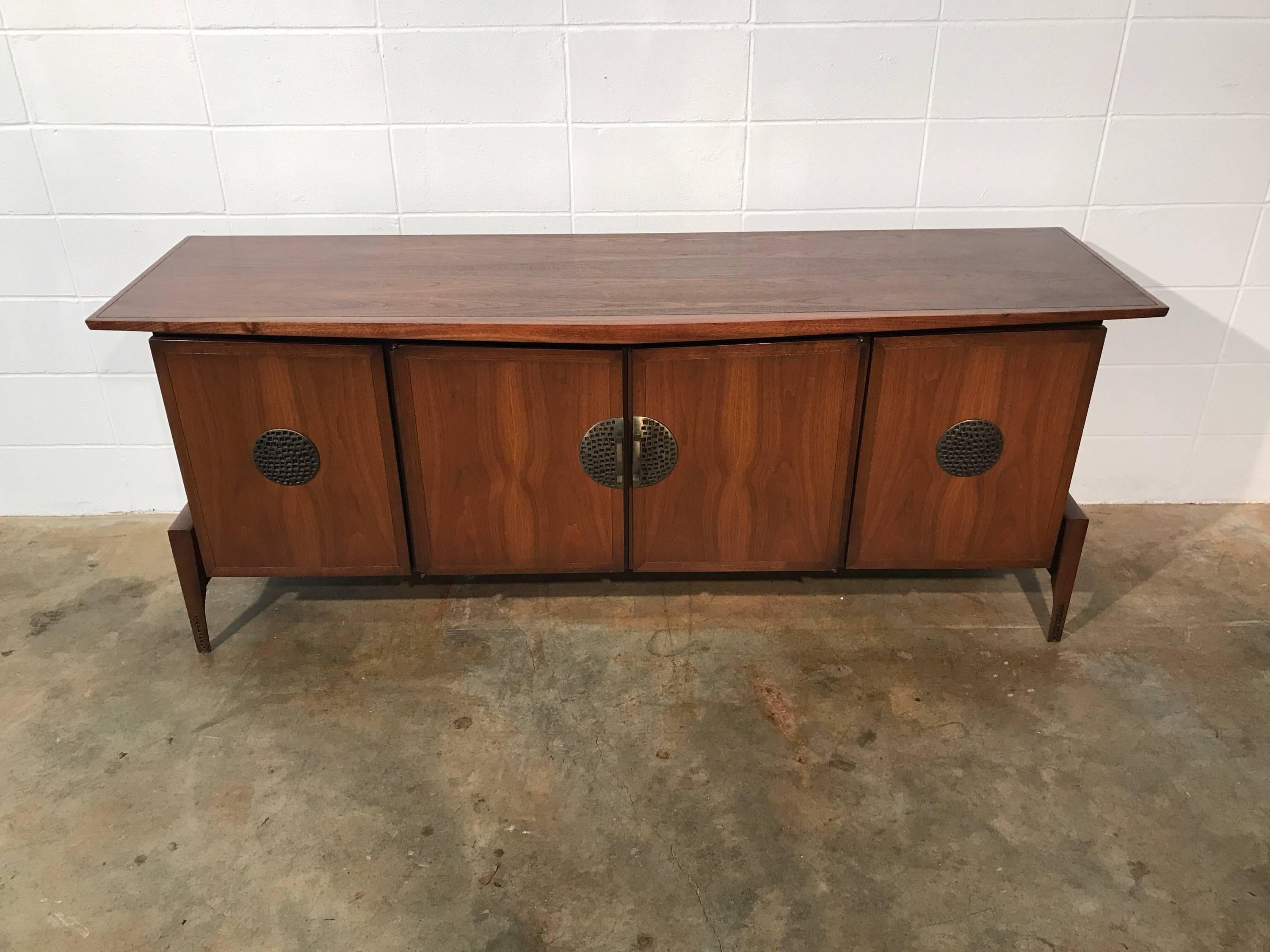 Sophisticated Mid-Century Modern credenza Asian flair - Hobey Helen Baker.
Mid-Century Modern credenza or dresser with clean and sleek lines yet unusually refined and sophisticated. Resting on a base with external legs its contains nine drawers