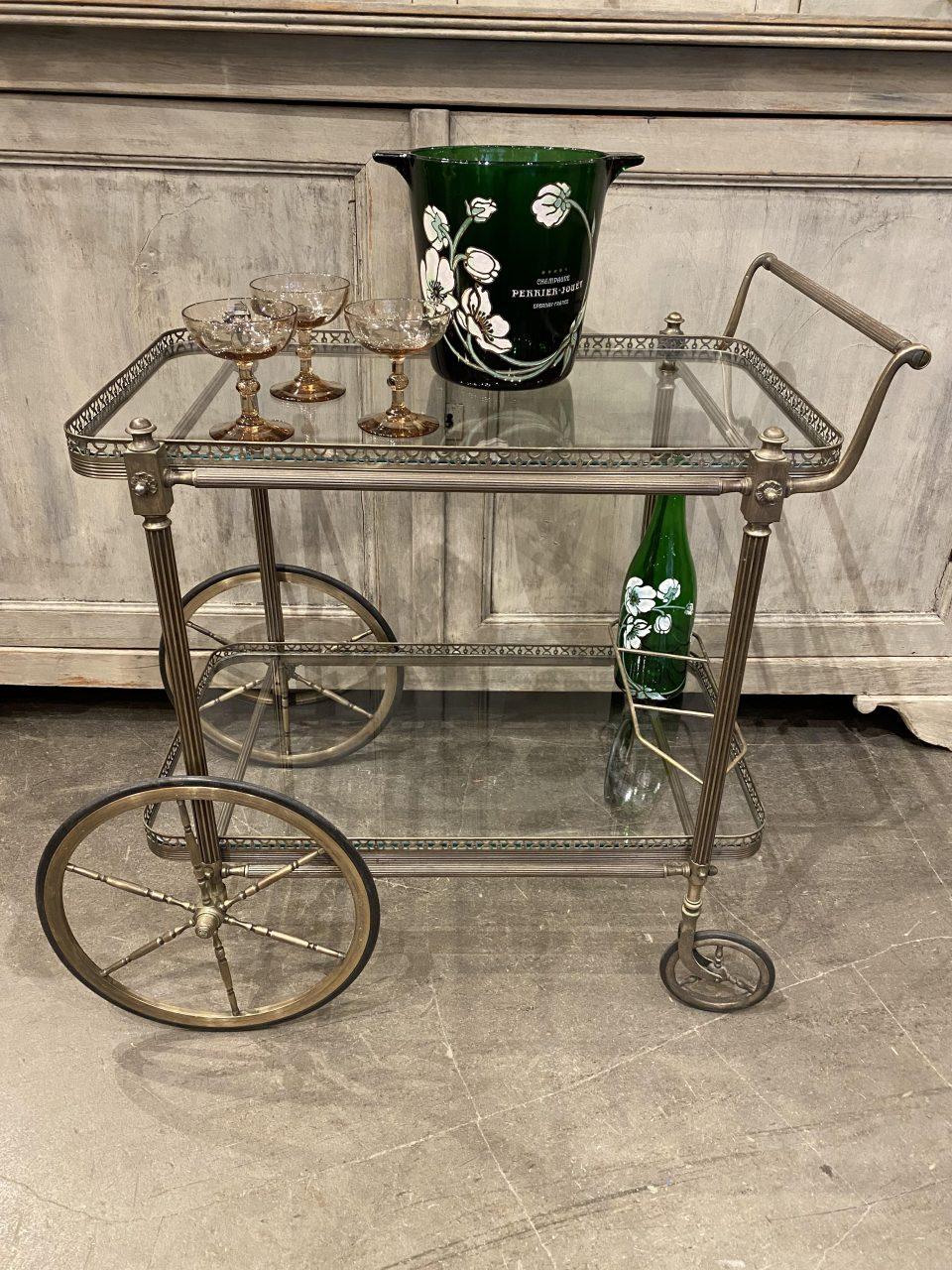 Delightful and presentable midcentury French barcart/ serving trolley. Made of nickel-plated brass, and equipped with handsome large Classic wheels, double glass shelves, bottle holder, and beautiful ornamentation on the sides of each leg.