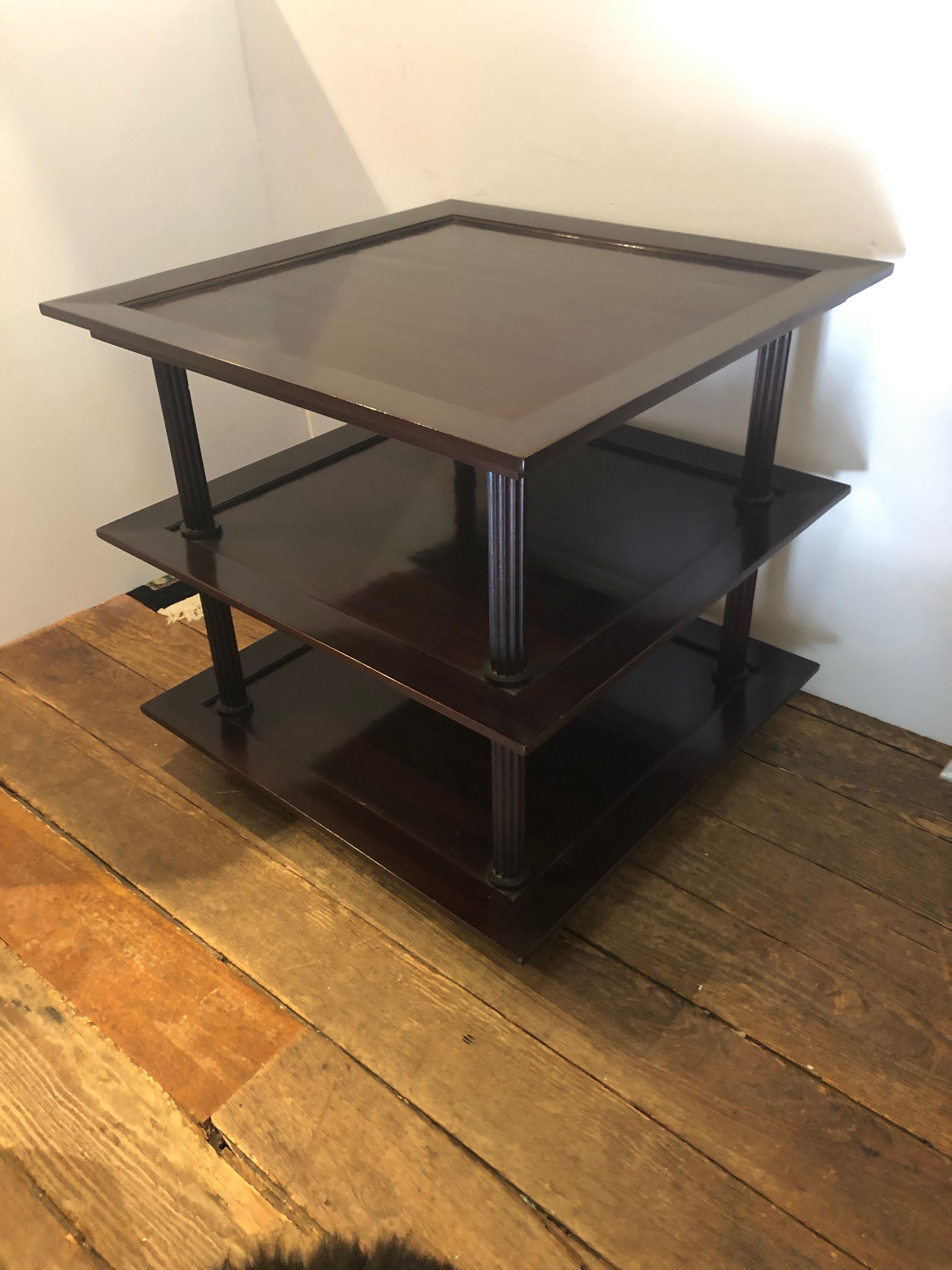 Two pristine very stylish 3-tier side tables by esteemed designer Barbara Barry for Baker, having reeded columns in each corner and a rich Java finish. The top tier has bevelled piece of glass that fits perfectly.