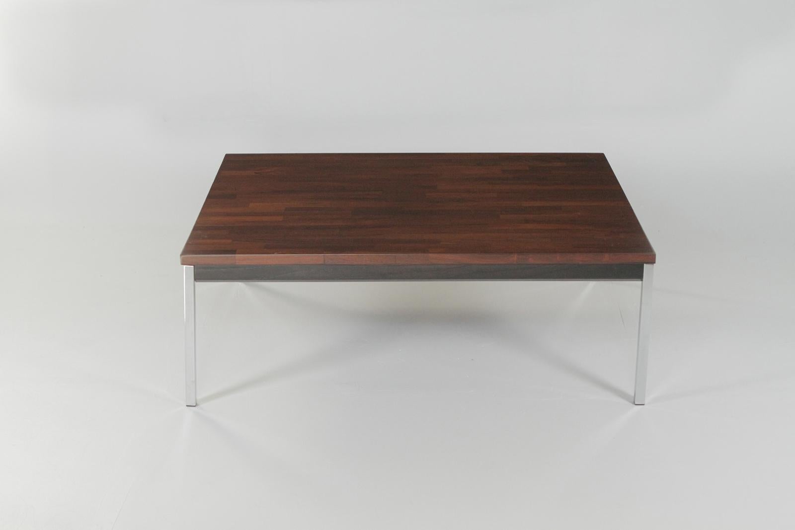 Une table basse élégante de style moderne du milieu du siècle avec un magnifique plateau en placage de bois de rose, un tablier en bois ébonisé et des pieds droits simples en chrome.

Non marqué mais ressemble à Knoll.