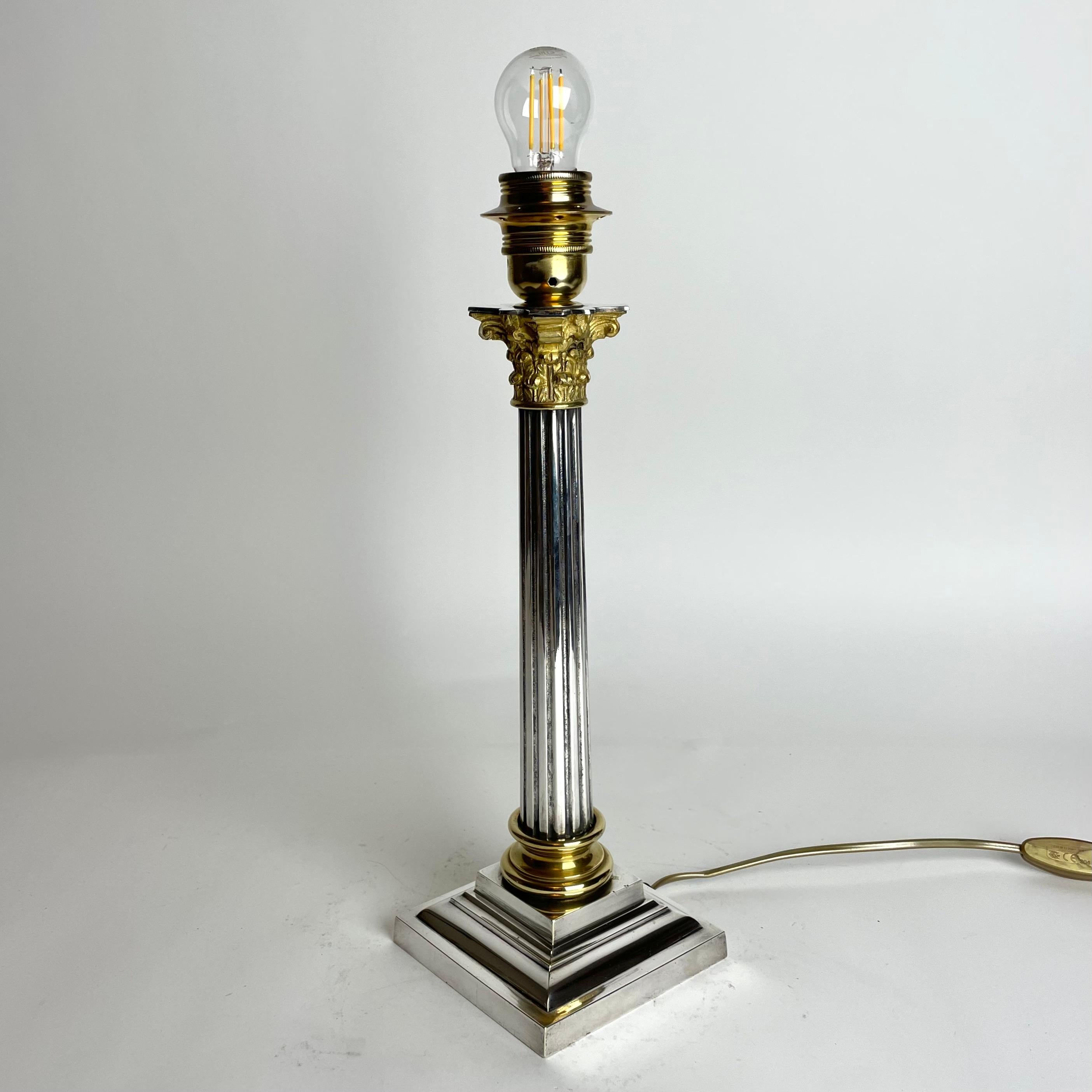 Raffinierte versilberte Tischlampe mit Messingdetails. Klassische Säule mit korinthischem Kapitell aus dem späten 19. Jahrhundert. Ursprünglich eine Petroleumlampe, die Anfang des 20. Jahrhunderts in eine Tischlampe umgewandelt wurde. Schöner