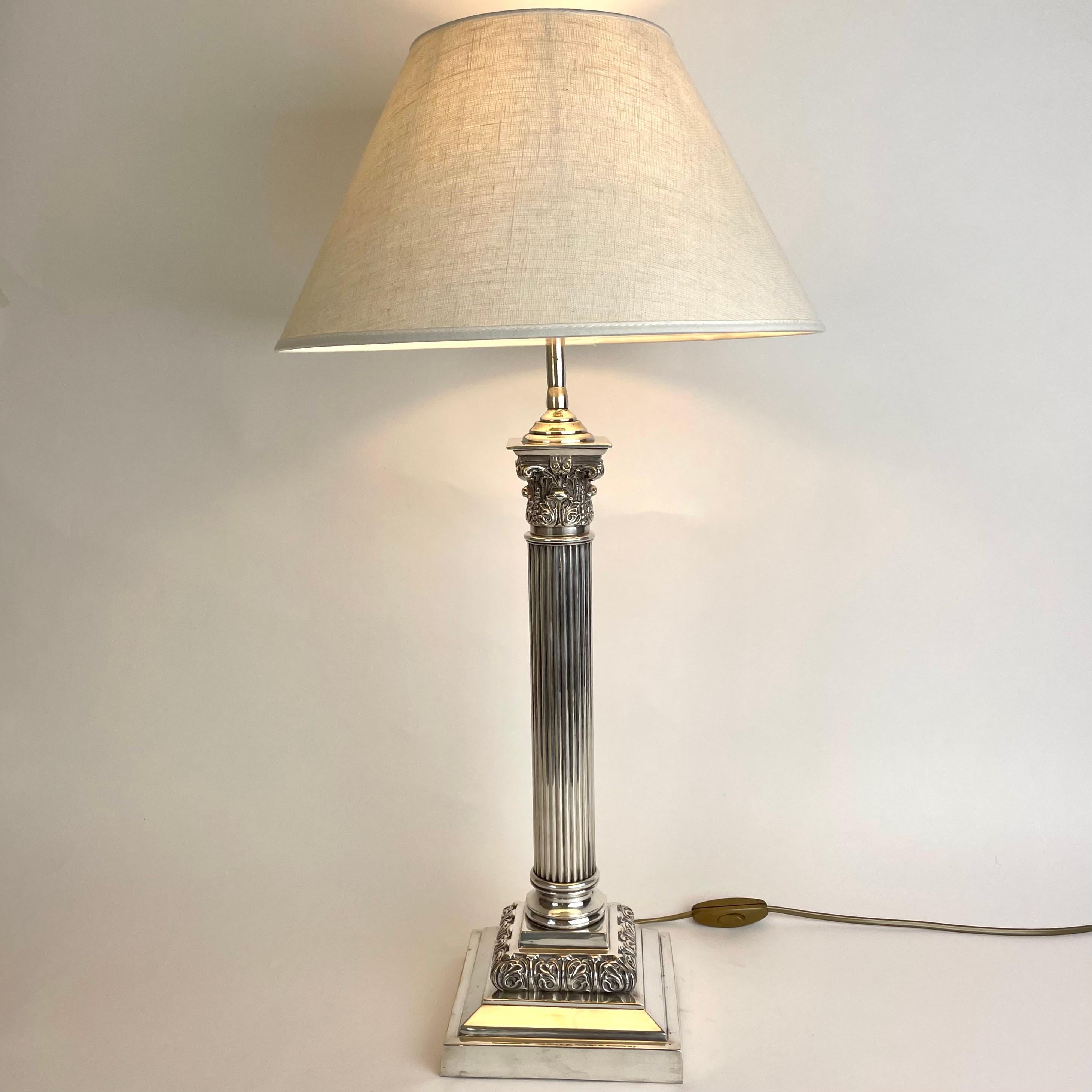 Raffinierte versilberte Tischlampe mit klassischer Säule aus dem späten 19. Jahrhundert. Ursprünglich eine Petroleumlampe, die Anfang des 20. Jahrhunderts in eine Tischlampe umgewandelt wurde.

Neu verkabelte Elektrizität 

Der Lampenschirm aus