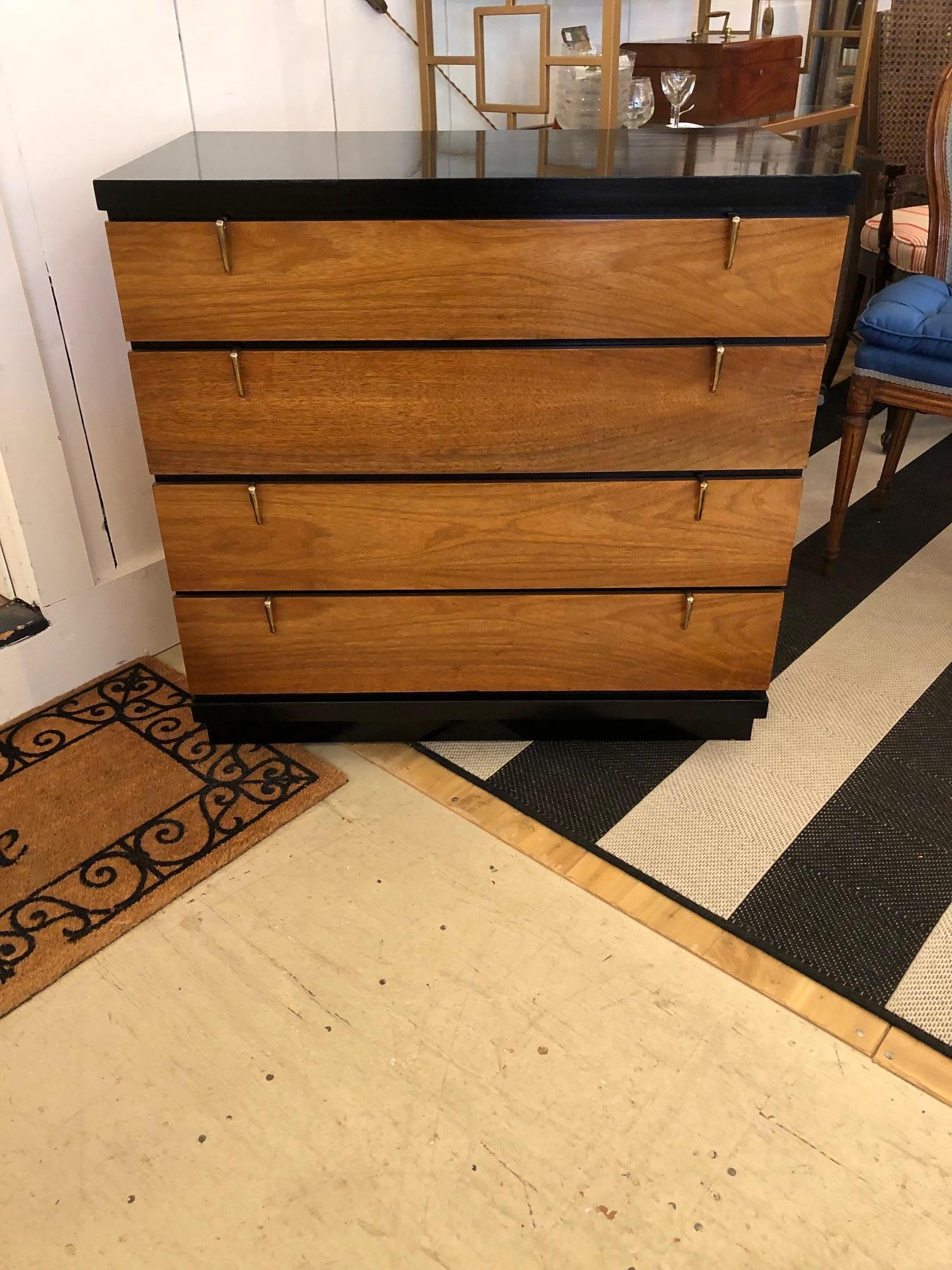 Sleek blonde walnut & ebonized wood chest of drawers having black formica top and four drawers. We love the brass stylish hardware and mid century silhouette. 
New glass to protect the top is included.  Maker is Johnson Carpen.