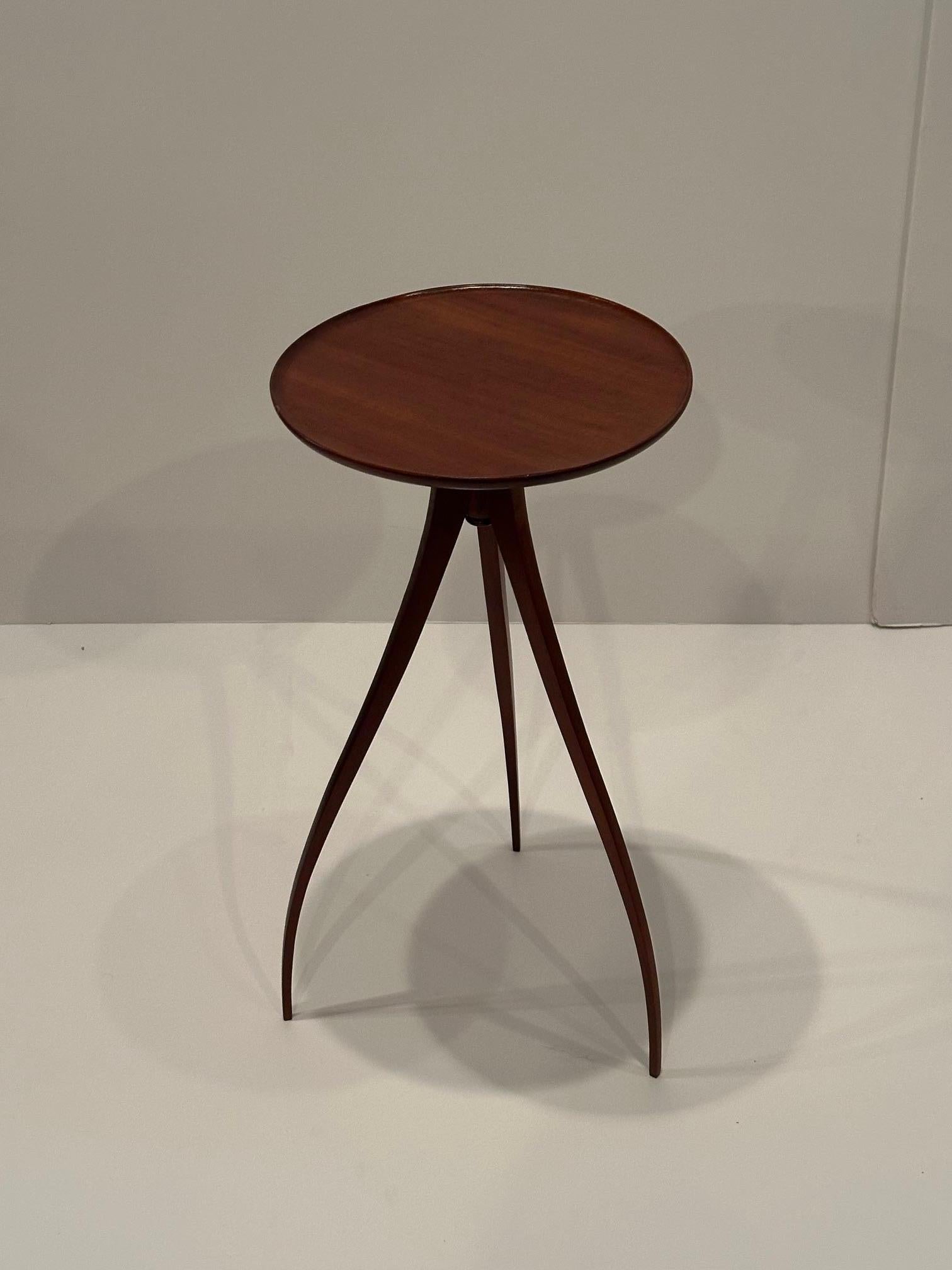 Magnifique table d'appoint ronde en acajou, de style moderne du milieu du siècle, avec une base tripode en forme d'araignée qui fait de cette table une véritable œuvre d'art.