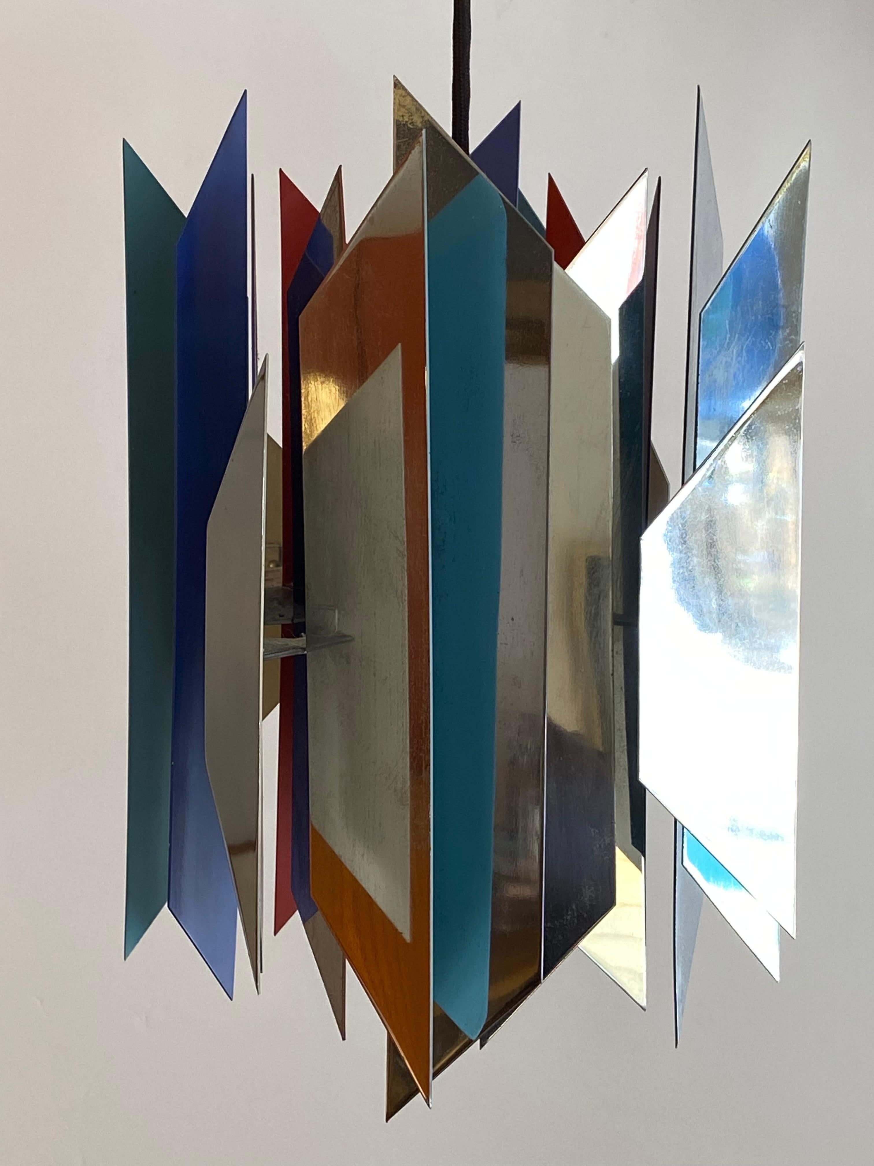 Soren Henningsen ceiling fixture, sold through Georg Jensen. 4 sided flat chrome finished shapes make up the exterior body of the light. Inside the pieces are painted blue, lilac, red and turquoise. Nice quality of light reflects from the interior