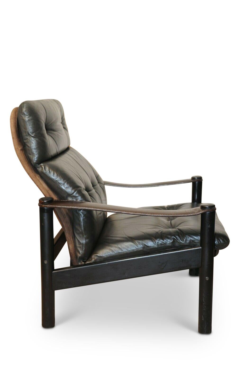 Soren Nissen & Ebbe Gehl Buttonback Safari chair with leather and suede sling arms. 

Dark leather open armchair very comfortable for lounging, and reading.
 