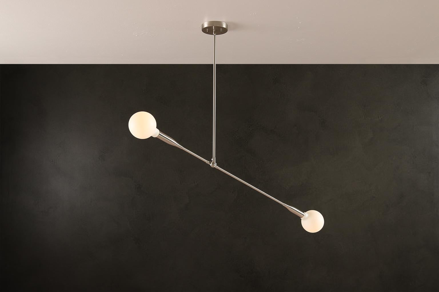 The Sorenthia Light is a modern, linear pendant with bold, elegant lines and dramatic negative space. The custom-made light fixture incorporates an element of the organic in its design language with a long, reaching arm that can be adjusted on site,