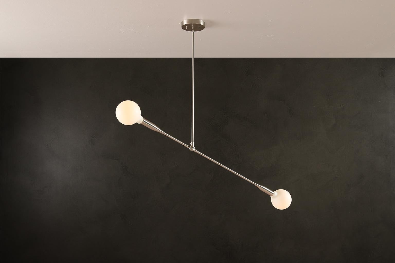 La lampada Sorenthia è una sospensione moderna e lineare, con linee audaci ed eleganti e uno spazio negativo di grande effetto. L'apparecchio su misura incorpora un elemento organico nel suo linguaggio di design con un braccio lungo e allungato che