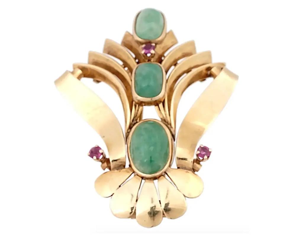 A retro American 14K Yellow Gold brooch made by Soret, Somers Ernst Co. Inc. The brooch is made in an openwork scrollwork design, and encrusted with hand carved Jade stones, and Ruby stones. Marked with a standard Gold hallmark, and a Soret mark, on