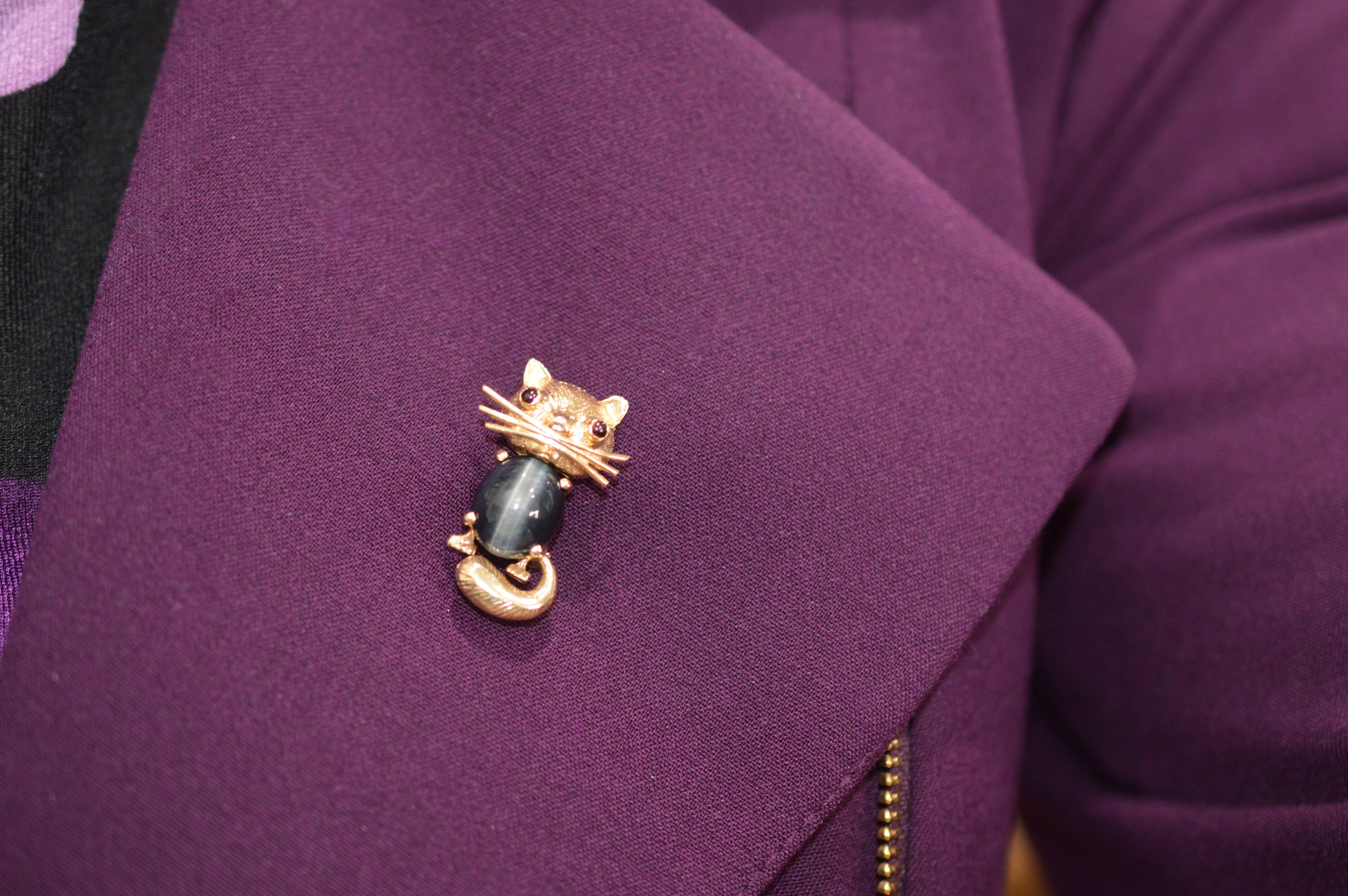 Enjoy this friendly feline lapel accent in fourteen karat yellow gold. This vintage Soret signature brooch pin by Somers Ernest Co. is crafted with a cat's eye quartz cabochon and enhanced with colorful amethyst and citrine eyes. Measures 1-1/8 inch
