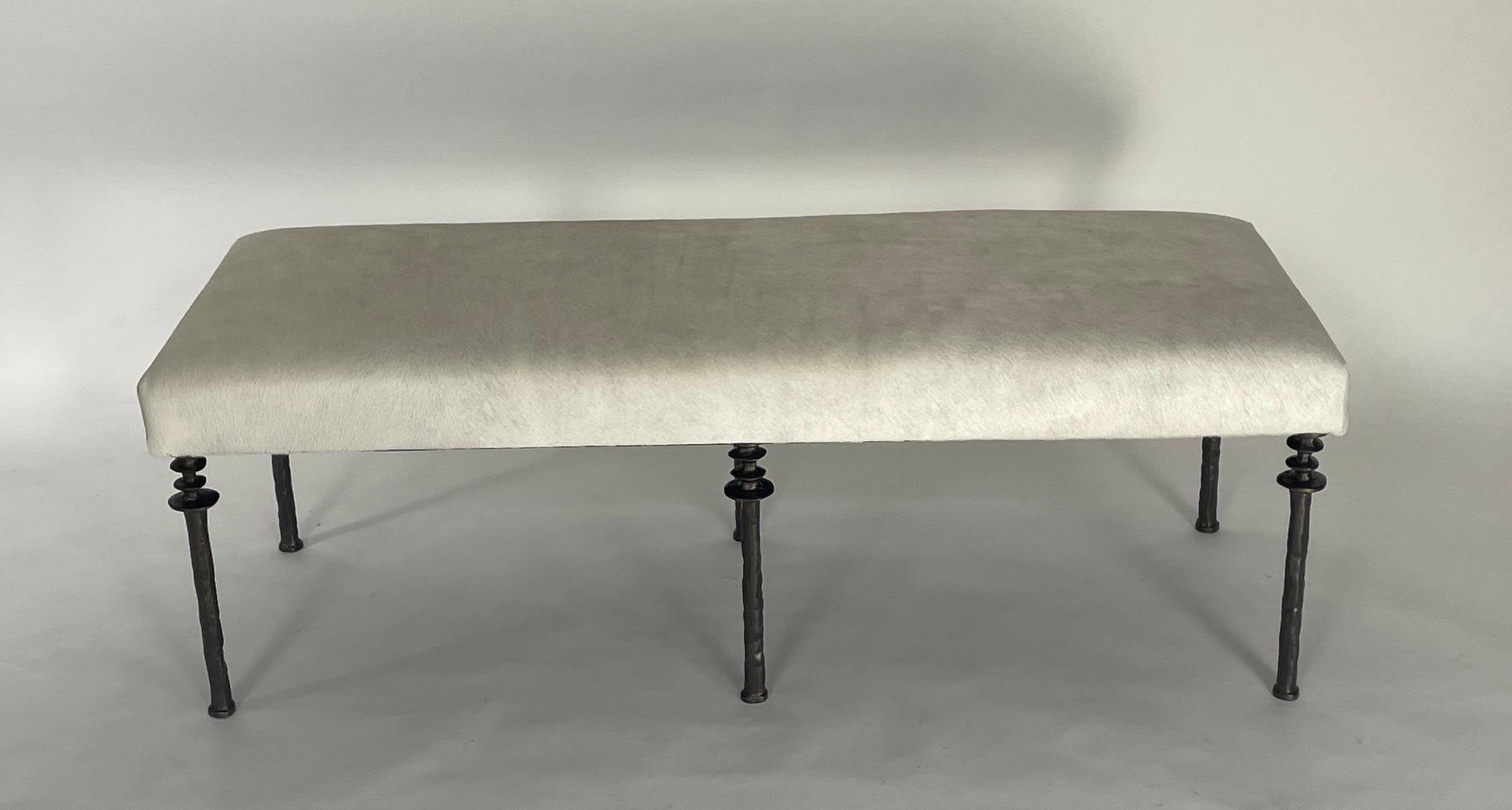 Inspired by Diego Giacometti, this bench is ideal for those who are looking for unique seating. Their cast bronze legs provide a truly organic touch. The cushion has been upholstered with an off white cow hide. The seat can be upholstered in a