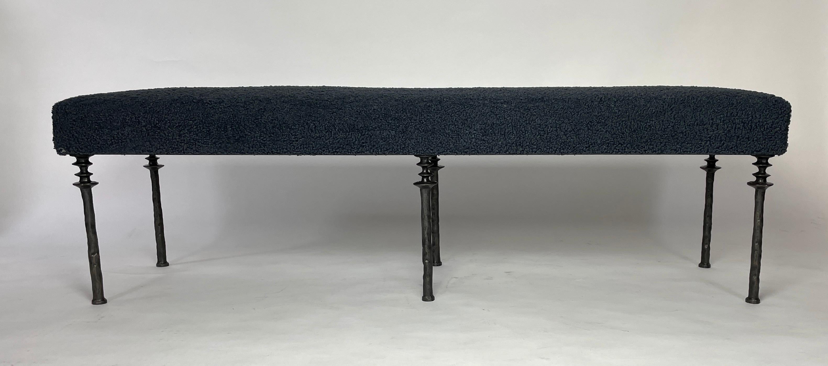 Inspired by Diego Giacometti, this bench is ideal for those who are looking for unique seating. Their cast bronze legs provide a truly organic touch. The cushion has been upholstered in a twilight blue boucle fabric. The seat can be upholstered in a