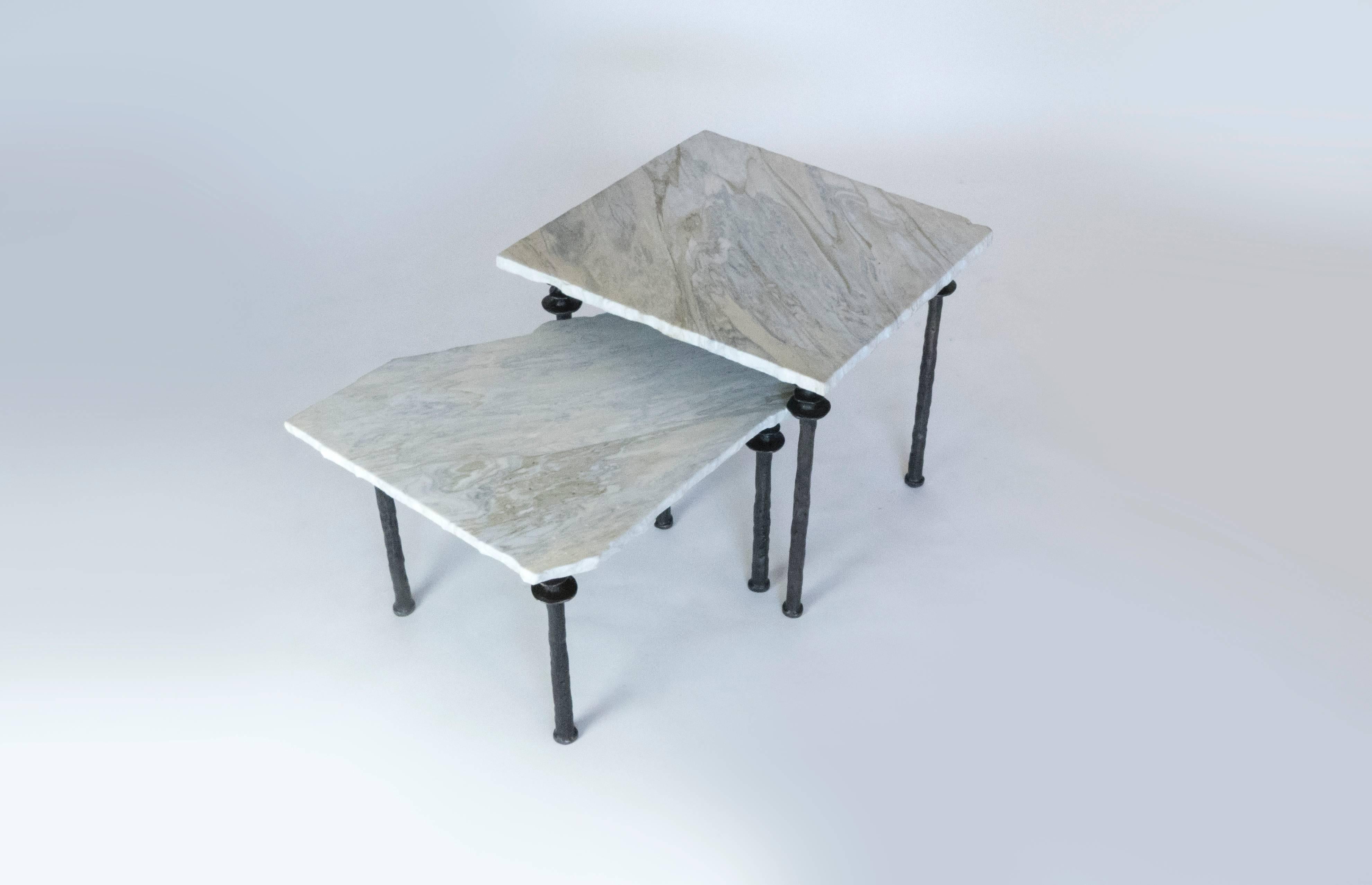 Two asymmetrical side tables with hand hewn marble tops. The legs are silicon cast bronze. Tables are of different heights. They can be arranged in various configurations. Largest table is H: 18