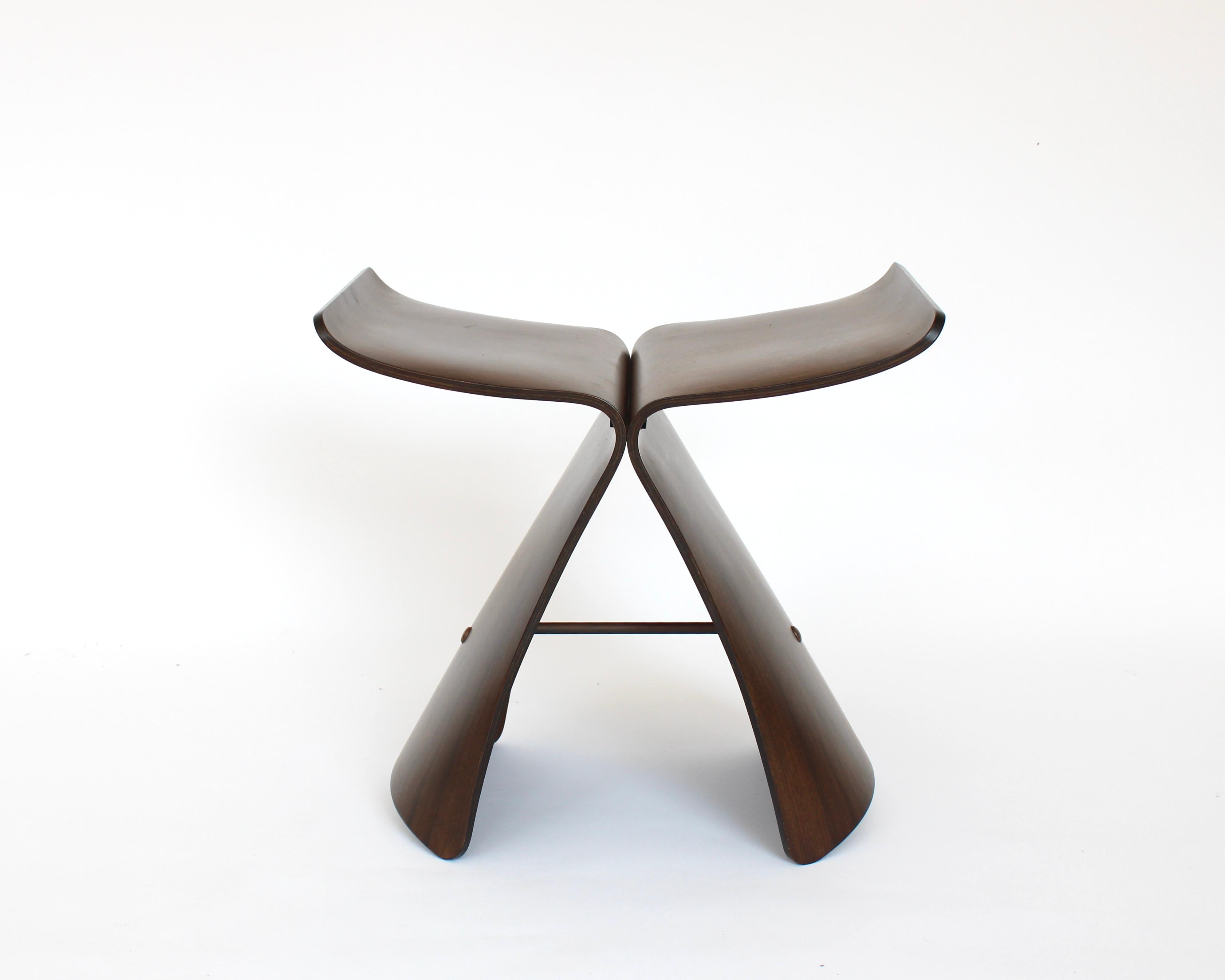 The Butterfly Stool by Sori Yanagi, (1915 - 2011) an iconic figure in Japanese industrial design.  Originally created in 1954 using the moulded plywood technique that had been newly created by the Eameses. 
Composed of two identical curved pieces of